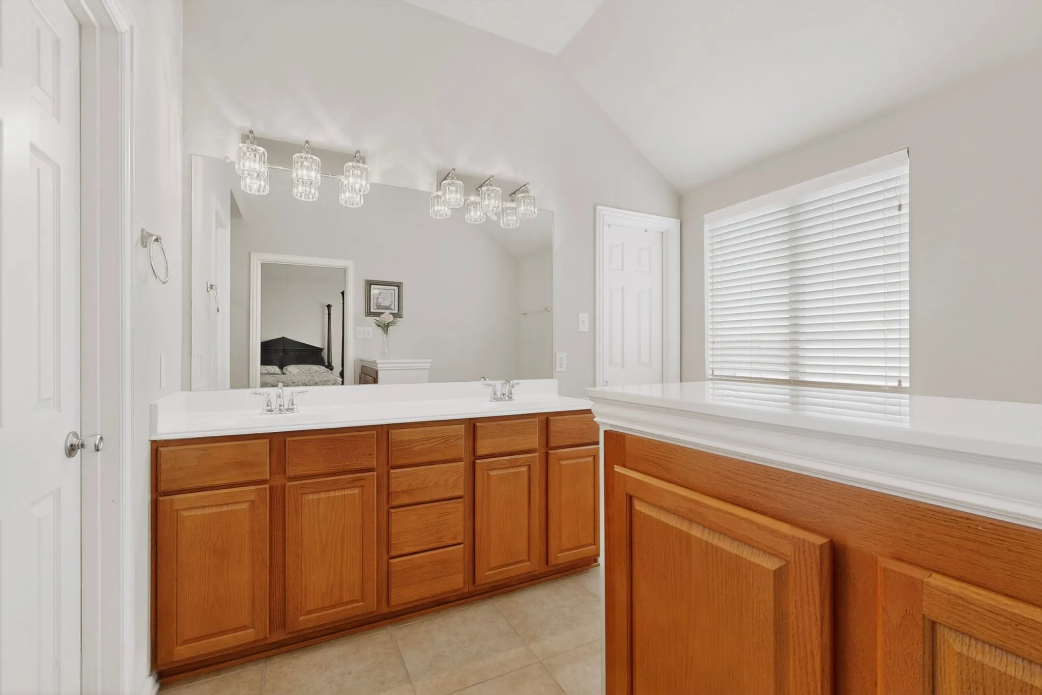Double vanity with wood-finish cabinetry and white countertops