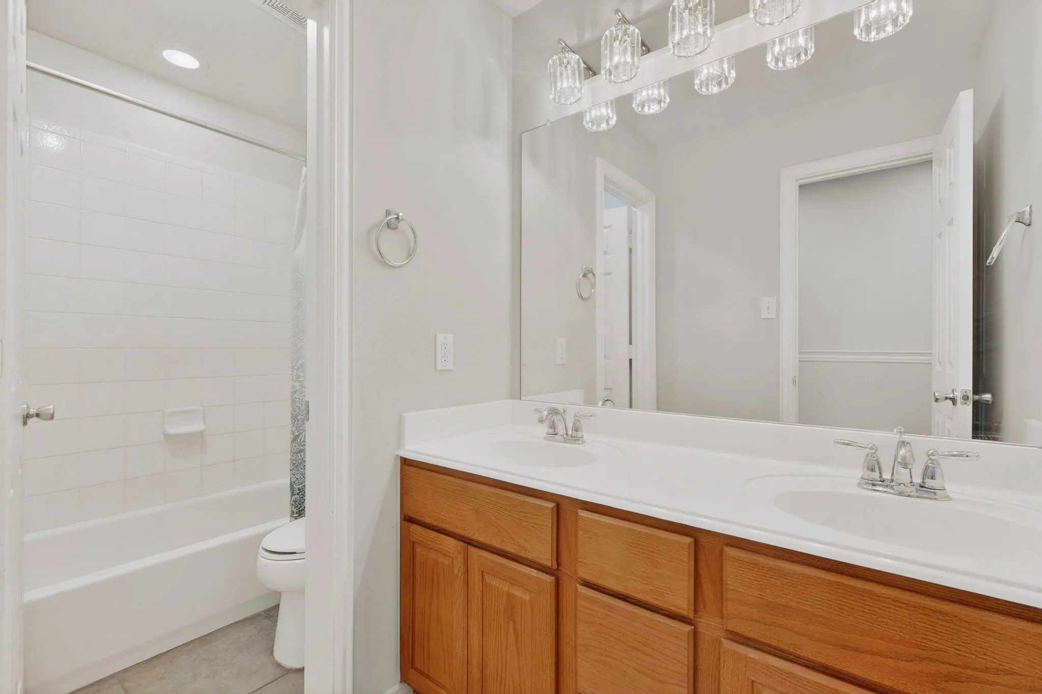 Bathroom with a double vanity featuring wood cabinetry, integrated sinks, and chrome fixtures