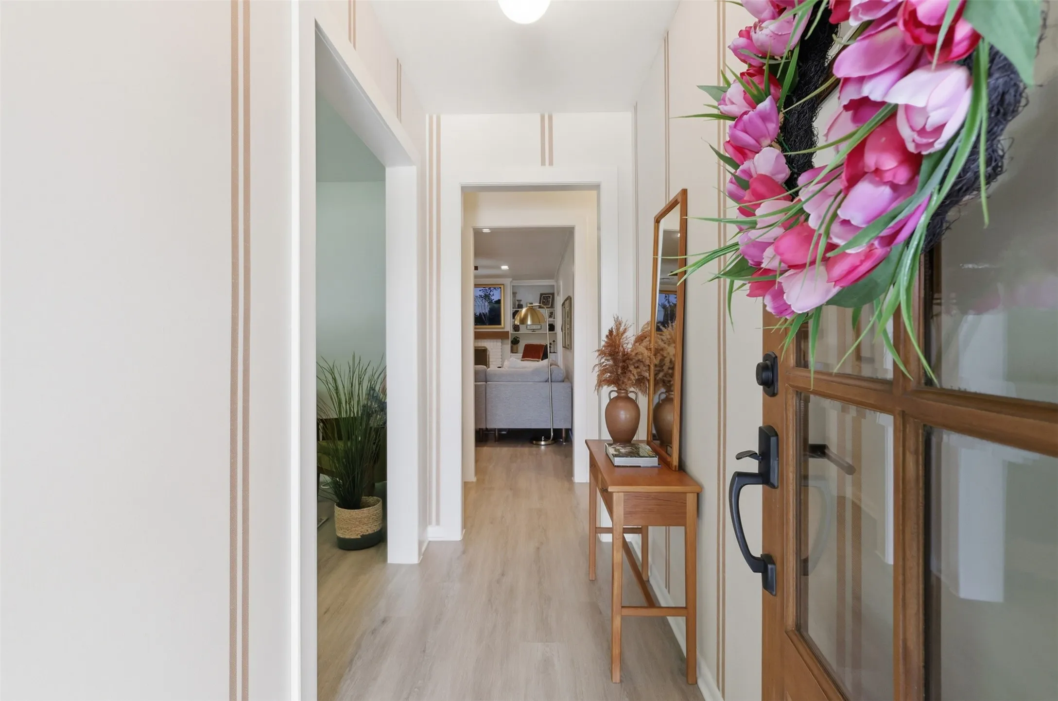 Inviting entry with front door with glass panels and professionally installed wallpaper.