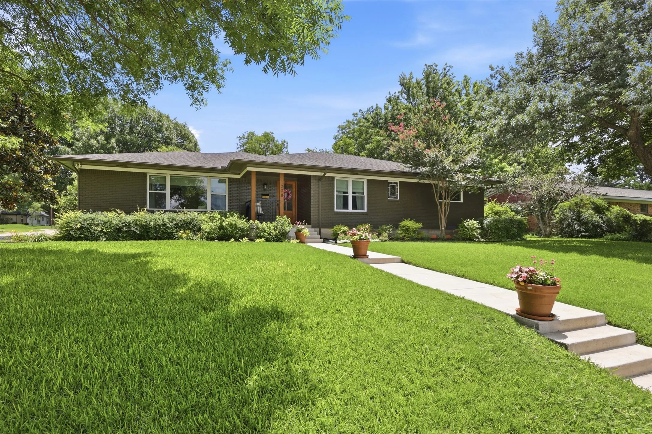 Exterior upgrades include extended sidewalk poured 2023, Painted brick in on trend neutral olive color, wood beams on front porch also installed in 2023, and new windows installed 2025.