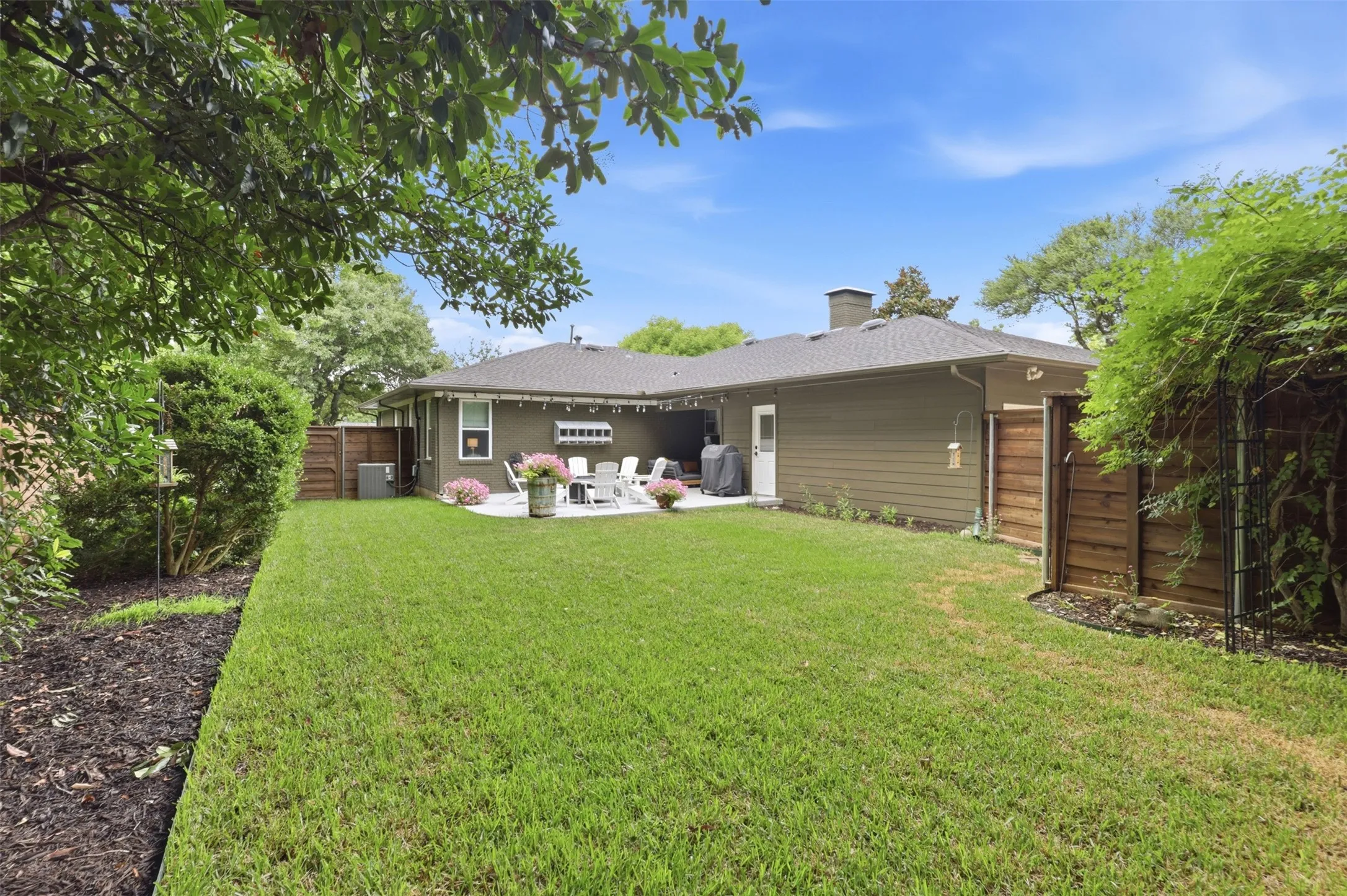 Backyard view showcasing the beautiful grass and landscaping.