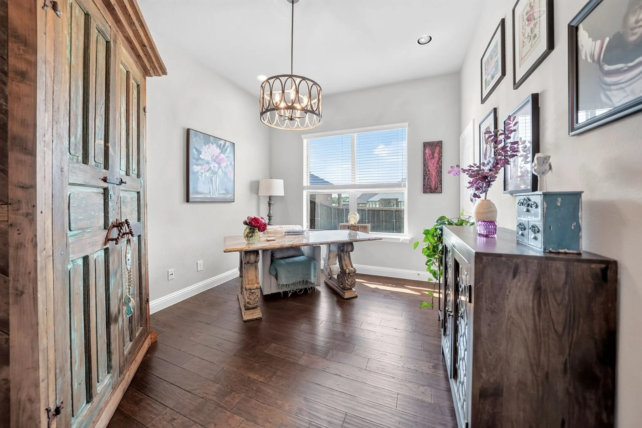 Room featuring dark wood-finish flooring, light grey walls, and a large window with blinds