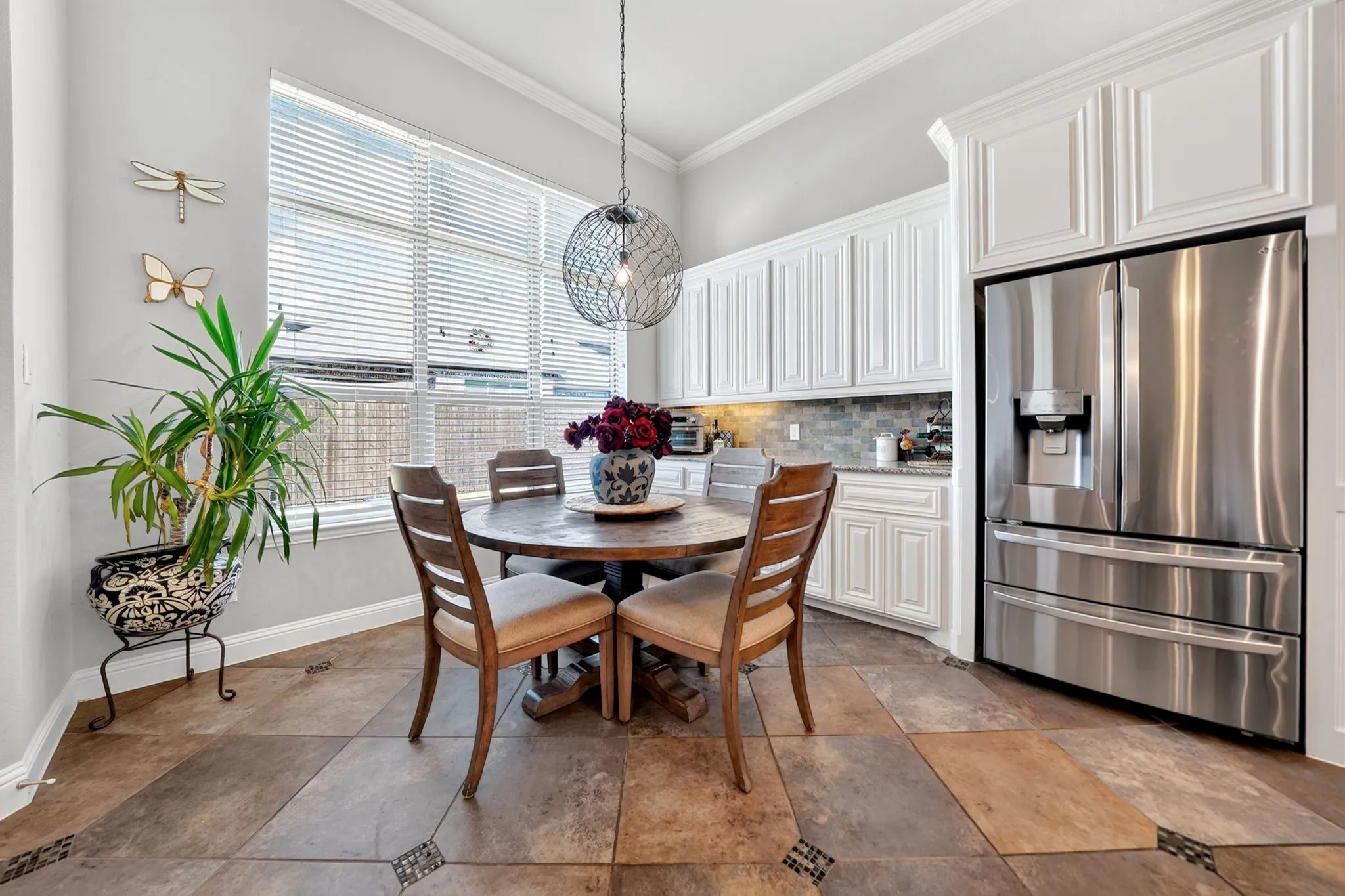 Spacious kitchen with a stainless steel French door refrigerator, white cabinetry, a neutral subway tile backsplash, and multi-toned tile flooring