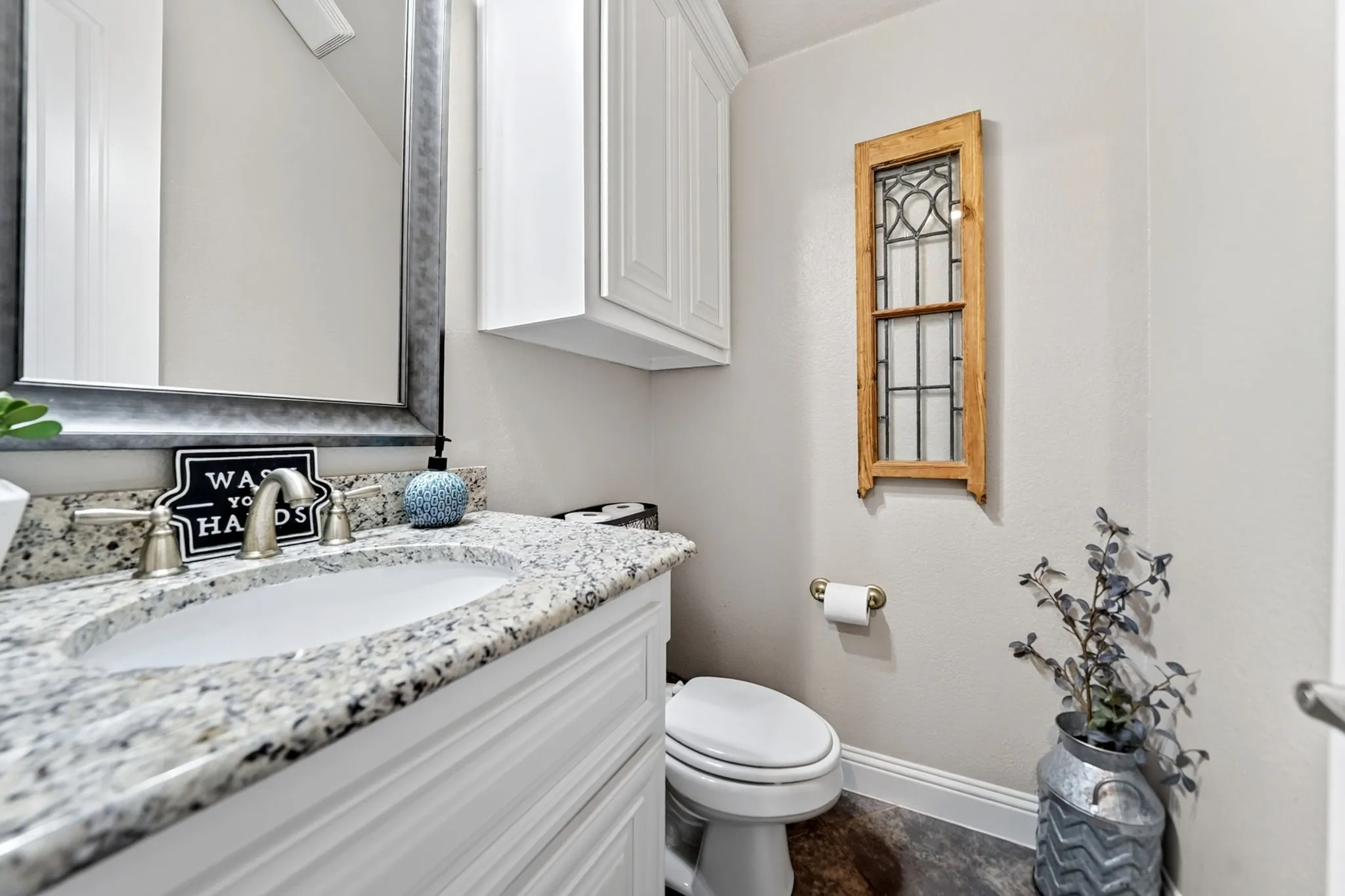 Vanity with a granite countertop and an undermount sink, complemented by a brushed nickel faucet set