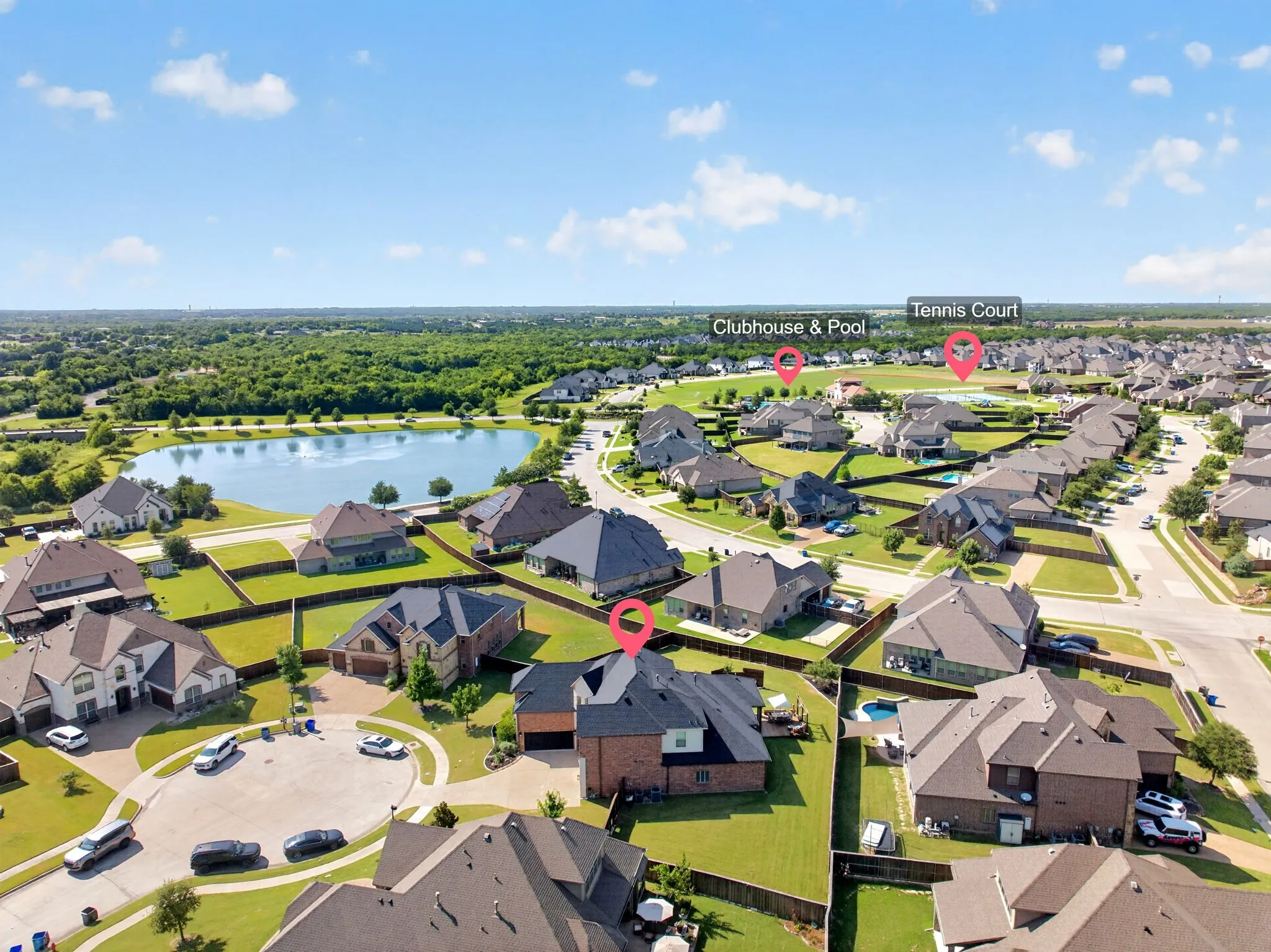 Aerial perspective showcasing a residential community with a large central pond