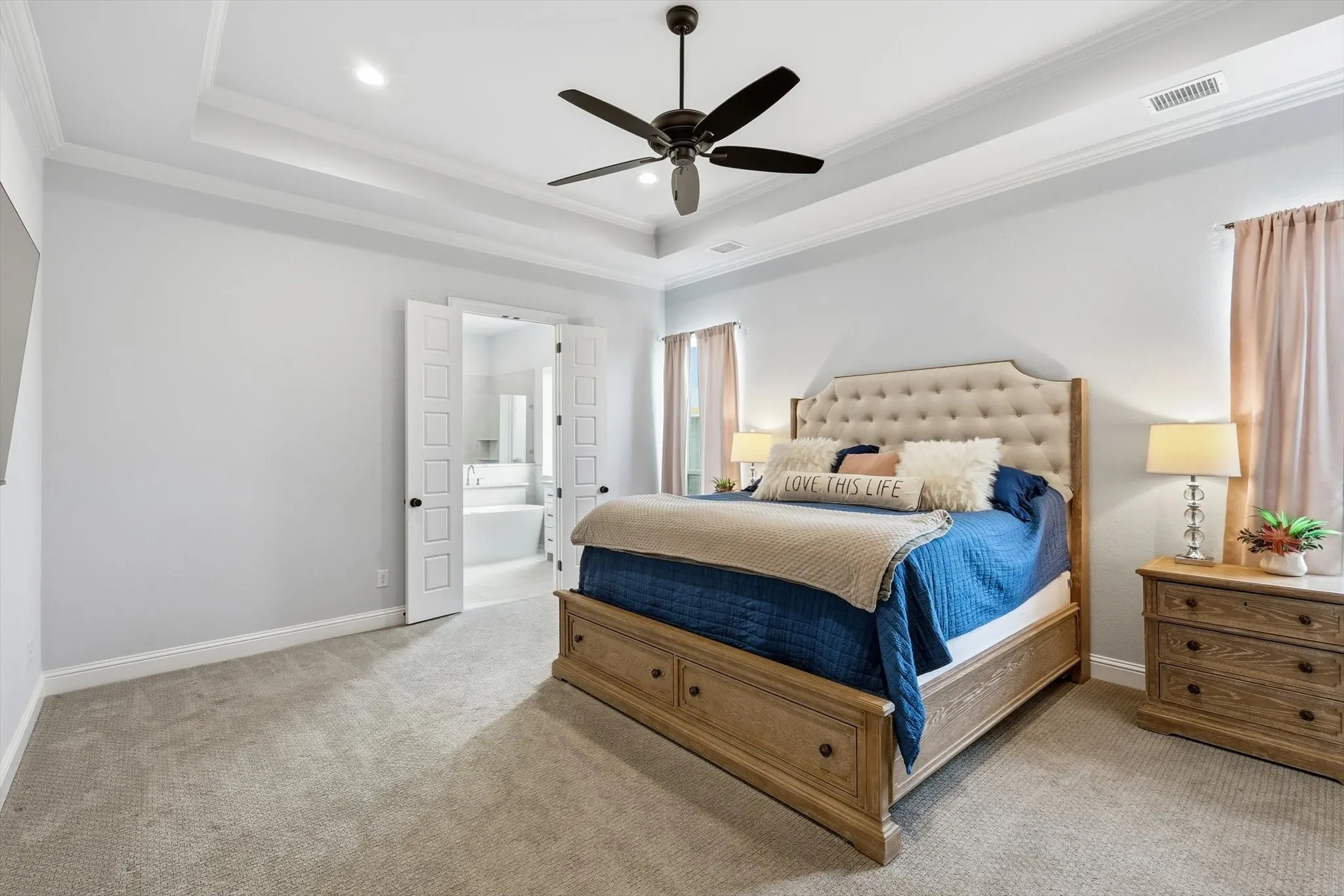 Bedroom featuring light gray walls, tray ceiling with recessed lighting and a ceiling fan, and carpeted flooring