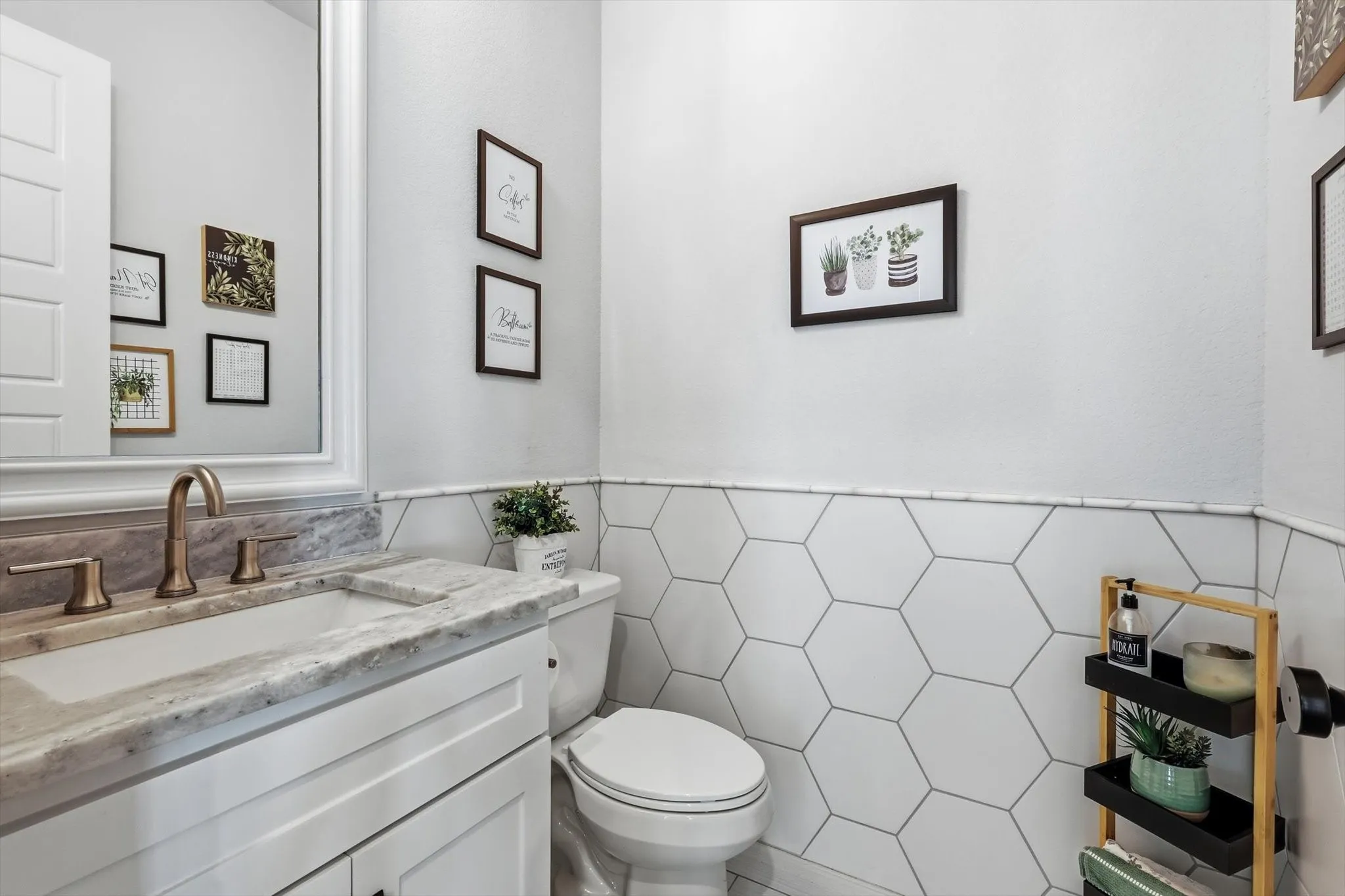 Jack & Jill bathroom featuring a white vanity with a stone countertop, an undermount sink, and a bronze-finish faucet