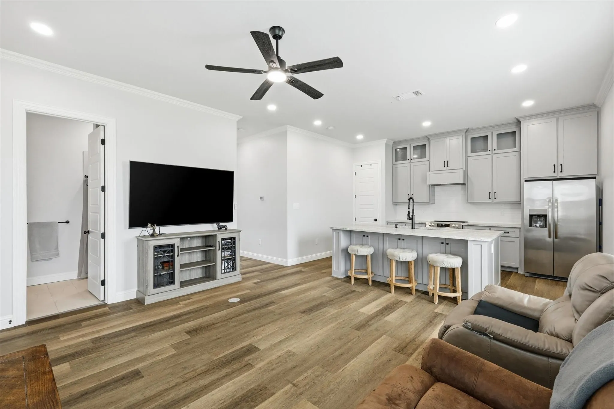 Guest Home - Open-concept living space featuring wood-finish flooring, recessed lighting, and a ceiling fan