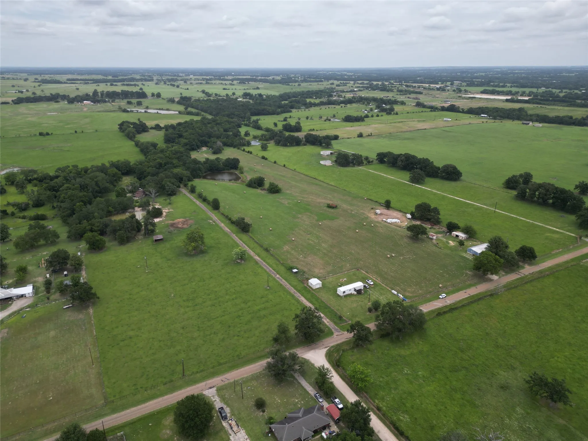 Expansive land parcel featuring open fields and mature tree lines