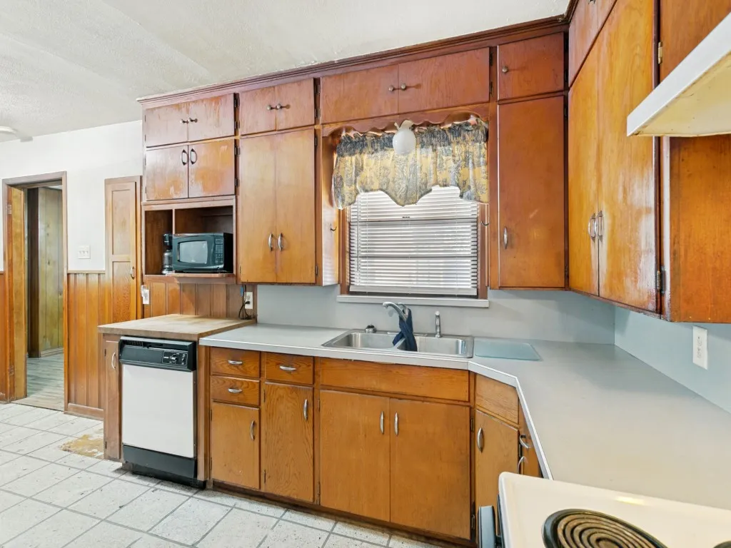 Ample countertop space and a built-in butcher block would please any home chef.  See the small door on the wall next to the dishwasher?  That's a pull-down ironing board!  Cute and functional!