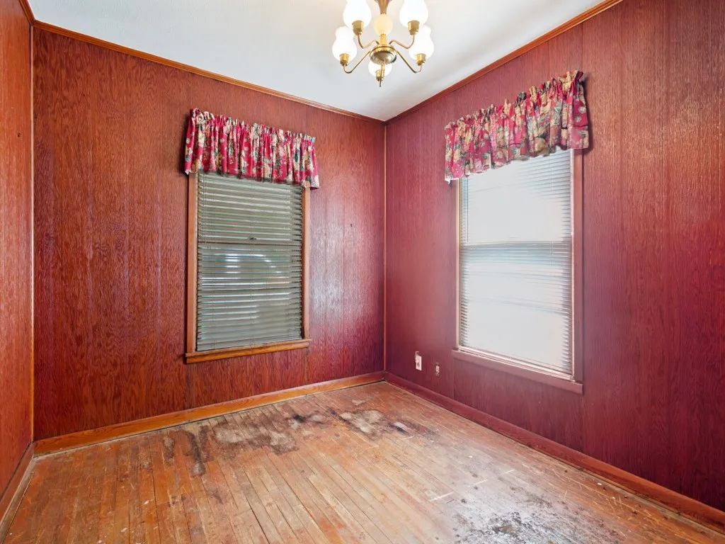 Dining room with hardwood floors and paneling.