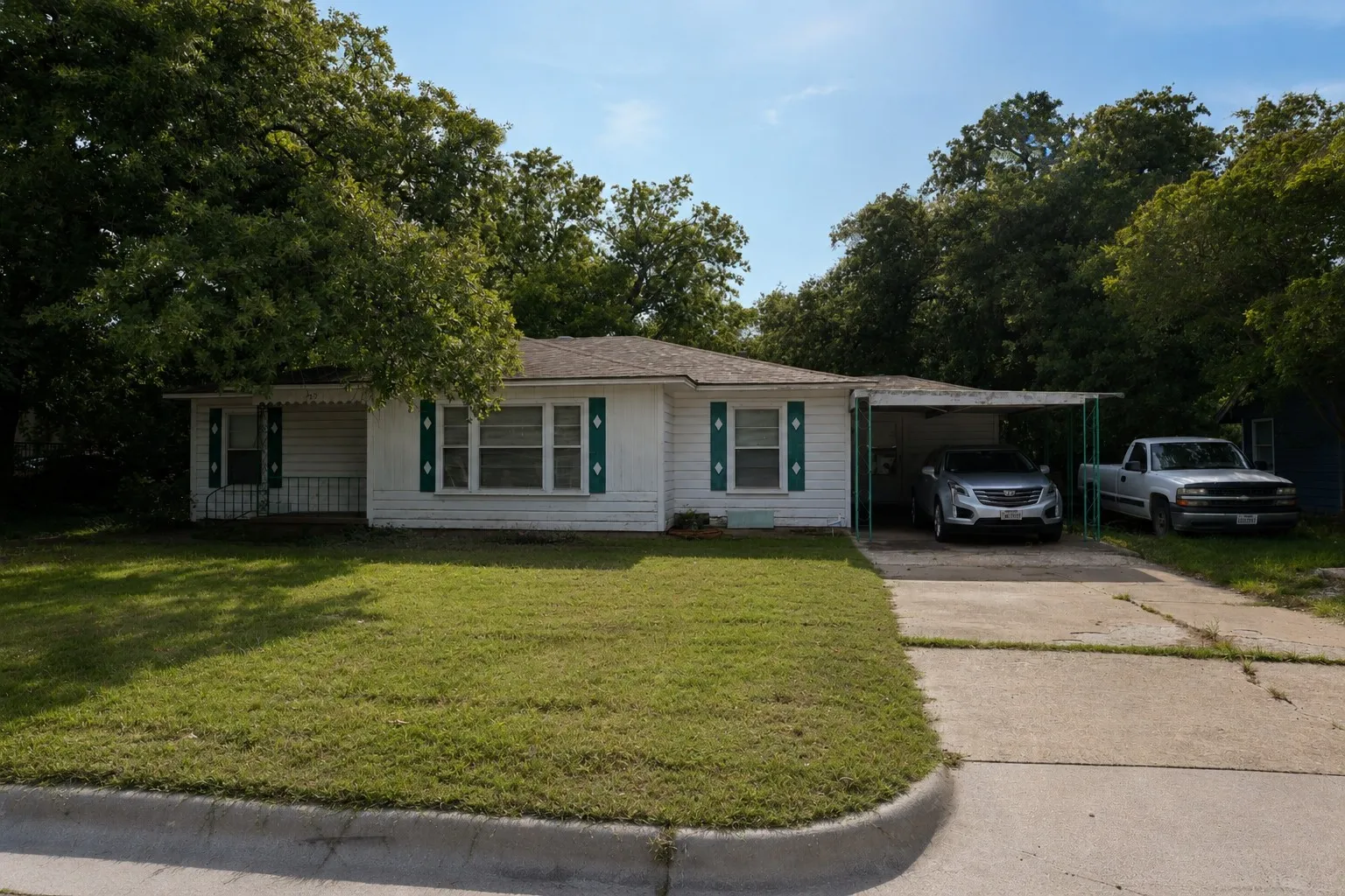 Charming 3-bedroom, 2-bath home with vintage shutters and trim.  Attached carport provides covered parking and a second entry into the home.  Notice the decorative iron columns.