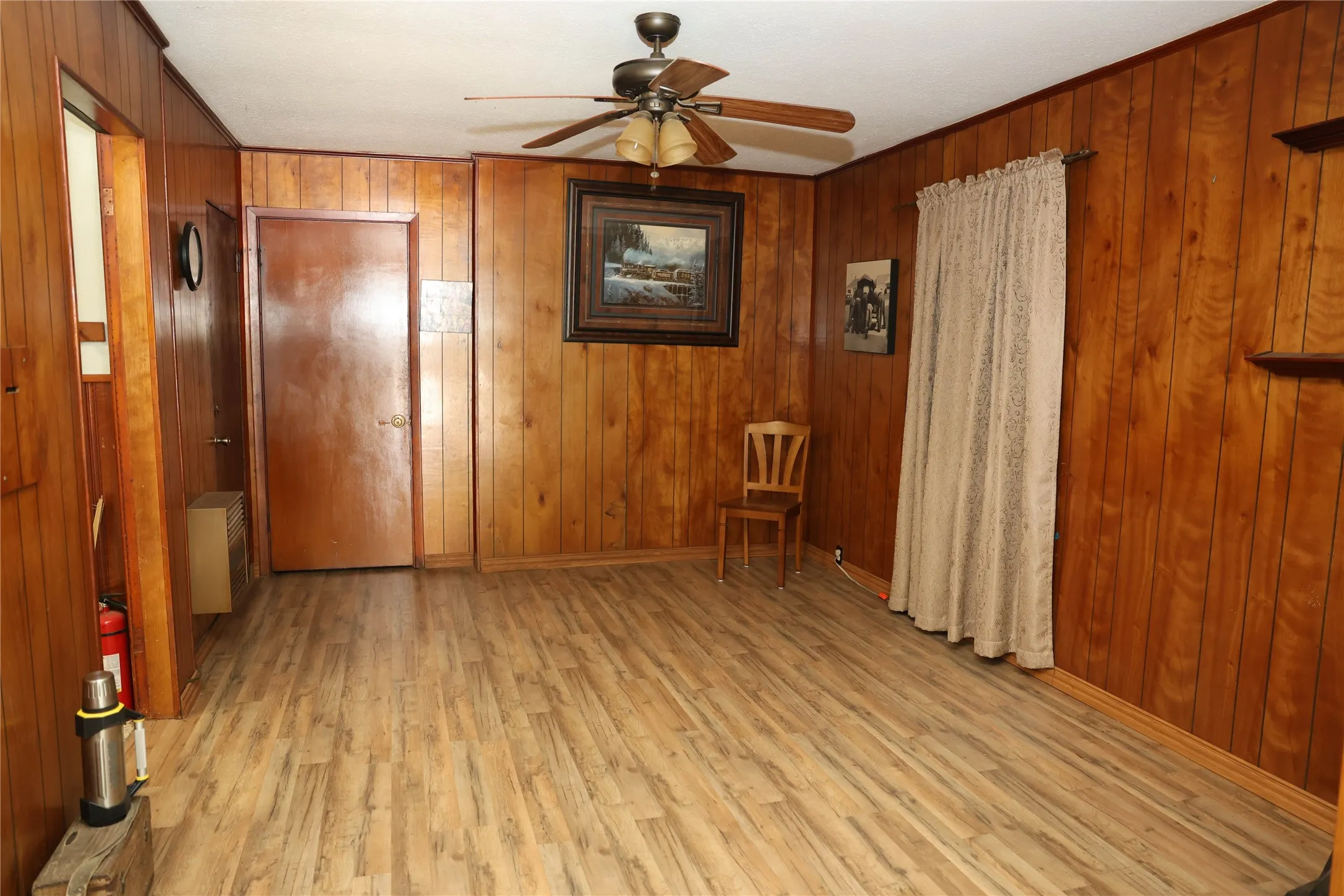 The view of the family room from the door that leads to the covered carport.  New flooring was recently laid.