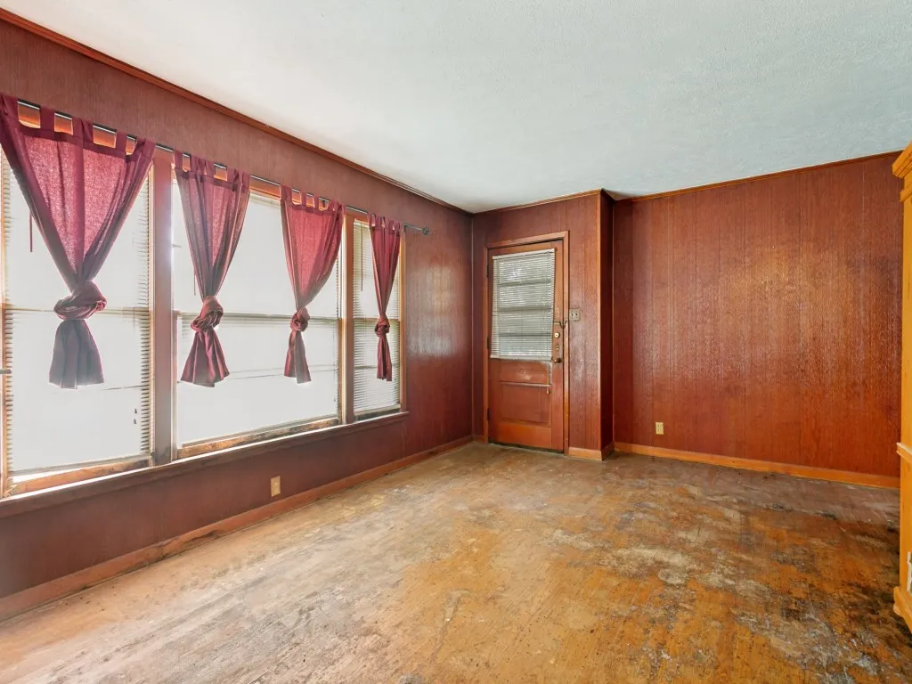 The front living room features large windows and the original wood floors.