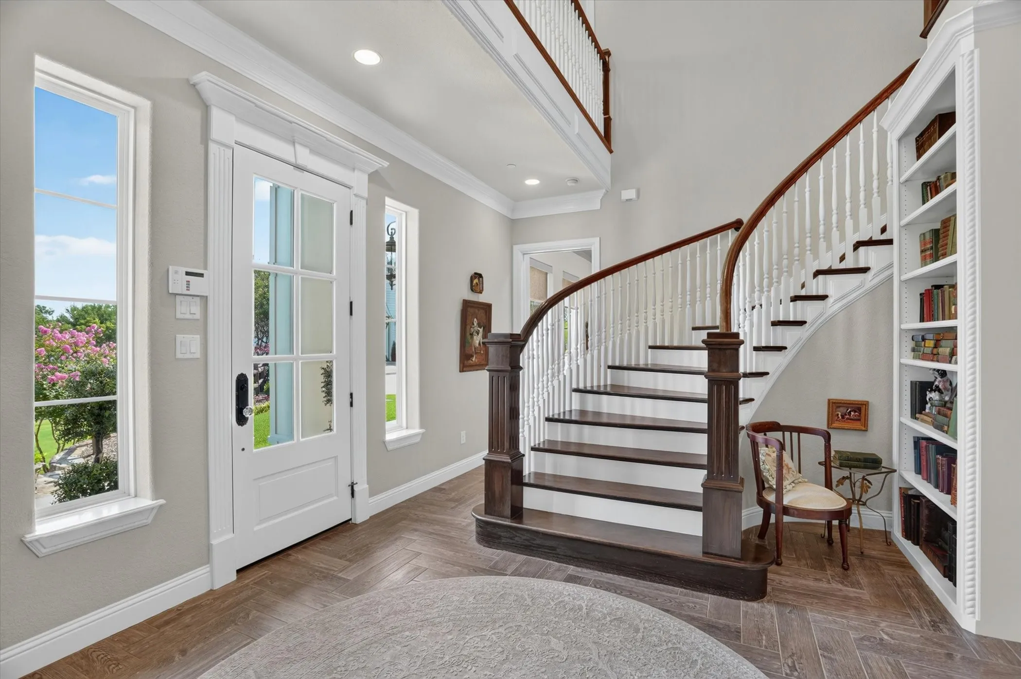 Grand entry featuring a curved staircase with dark wood treads and white balusters