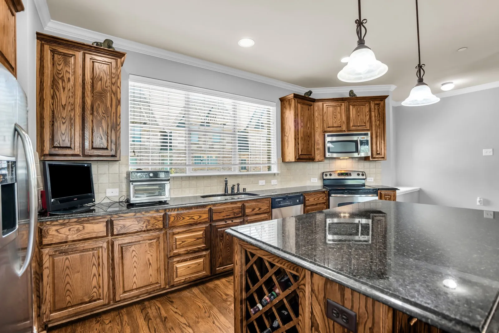 Kitchen featuring wood cabinetry, dark countertops, and stainless steel appliances