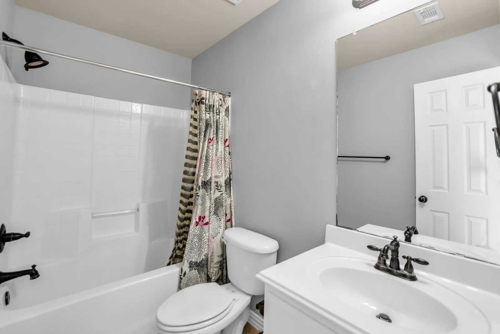 White vanity with integrated sink and dark bronze faucet