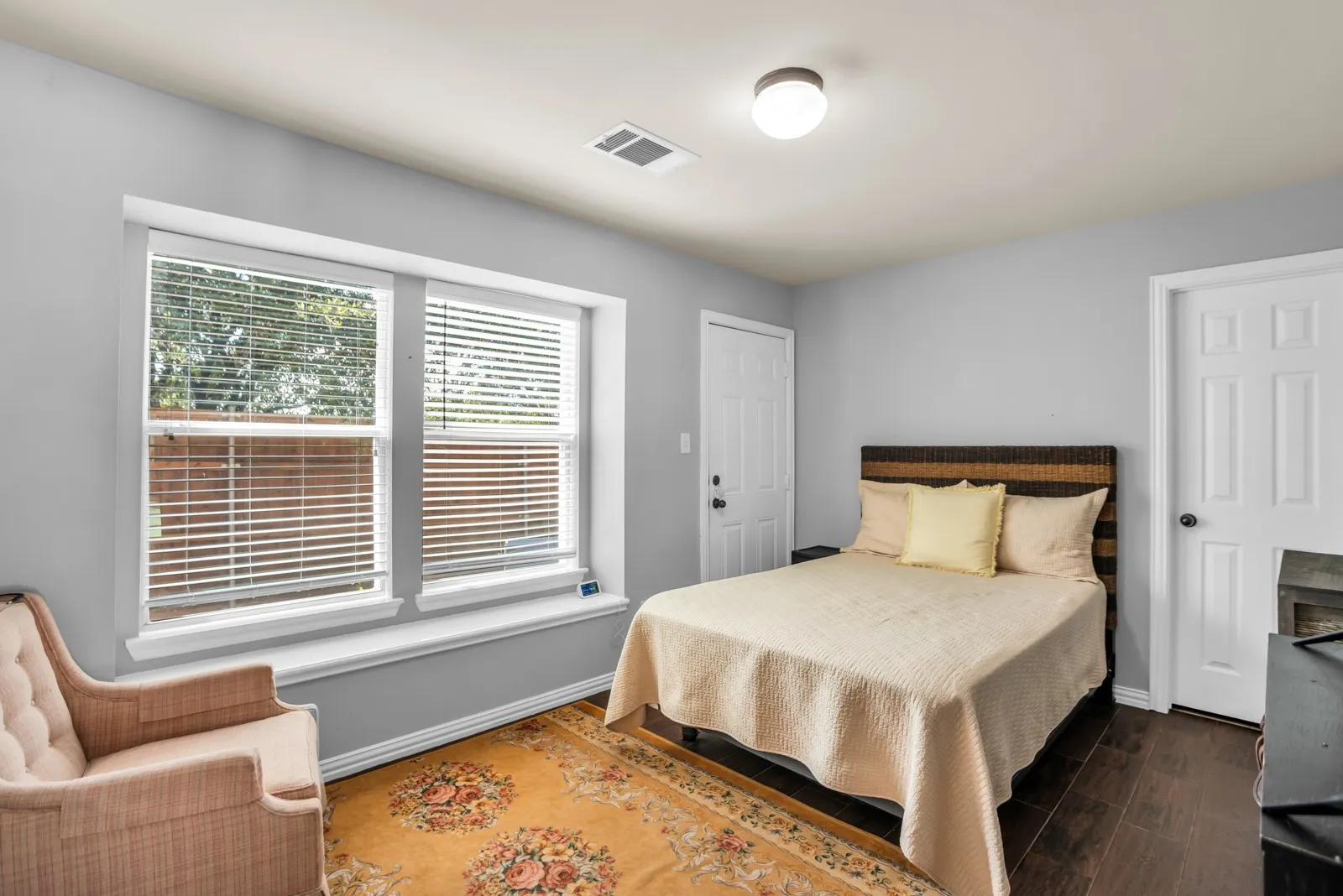 Spacious room featuring two large windows, wood-finish flooring, and a ceiling-mounted light fixture