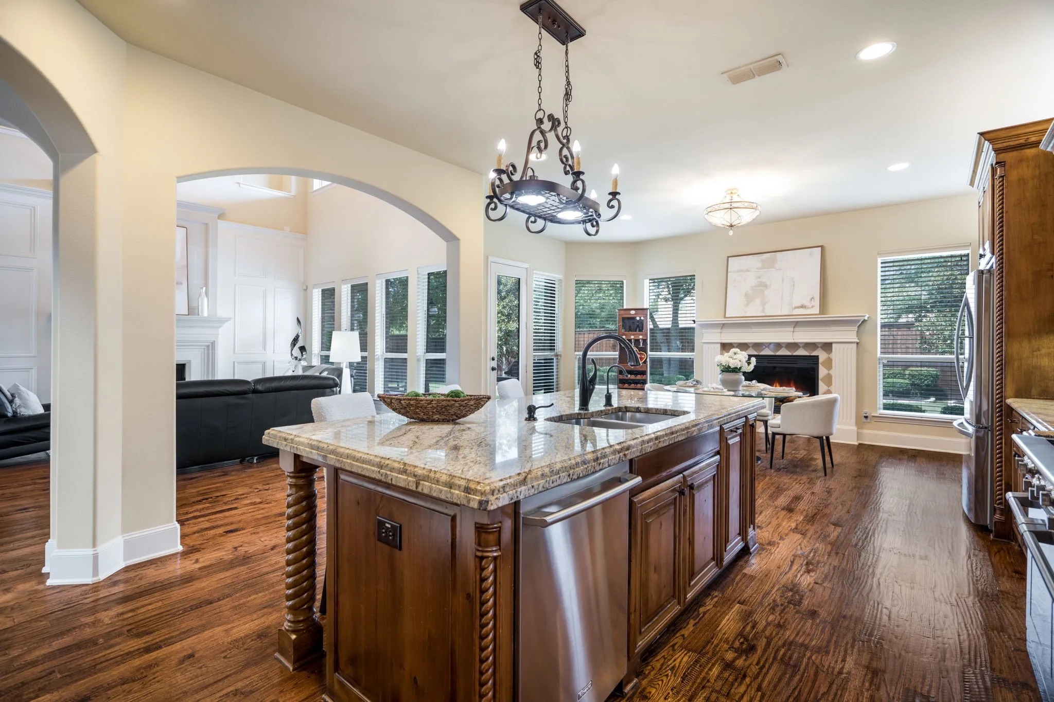Kitchen island with a granite countertop, undermount sink, and integrated dishwasher