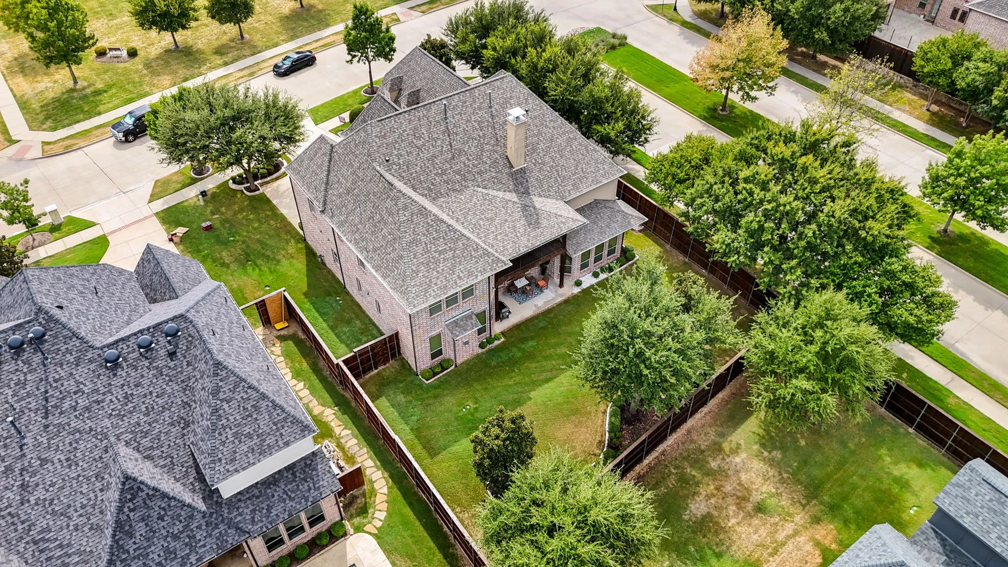 Two-story property featuring a gabled roofline, brick exterior, and a covered back patio