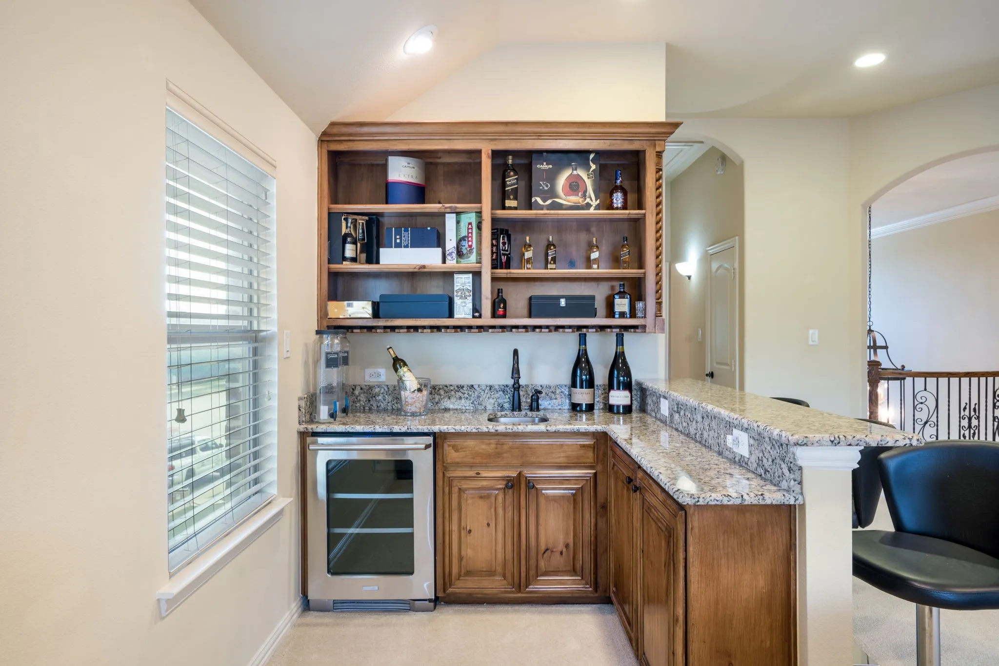 Vaulted ceiling with a ceiling fan, window with blinds, and neutral carpeting