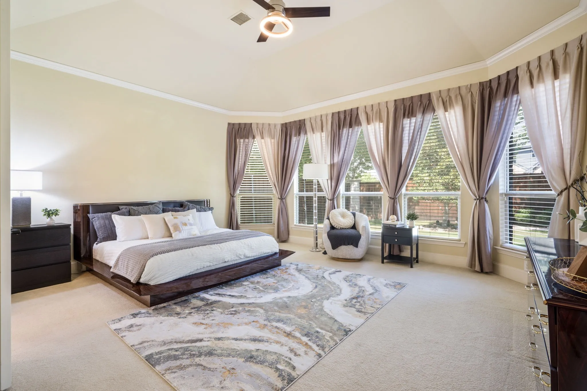Bay window with multiple large windows, white window blinds, light-colored carpeting, and light-toned wall paint