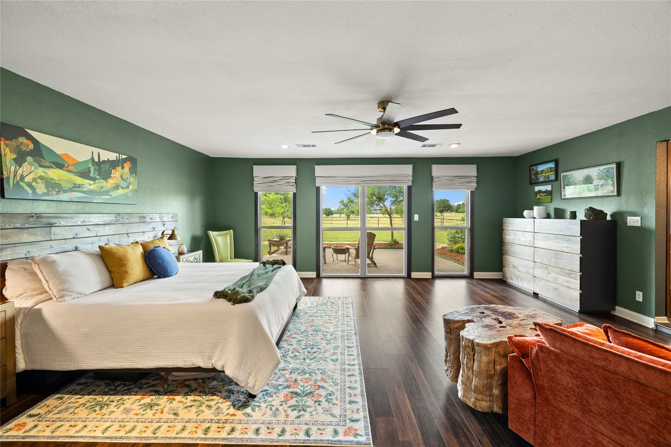Spacious room featuring wood-finish flooring, a contemporary ceiling fan, and a built-in reclaimed wood headboard