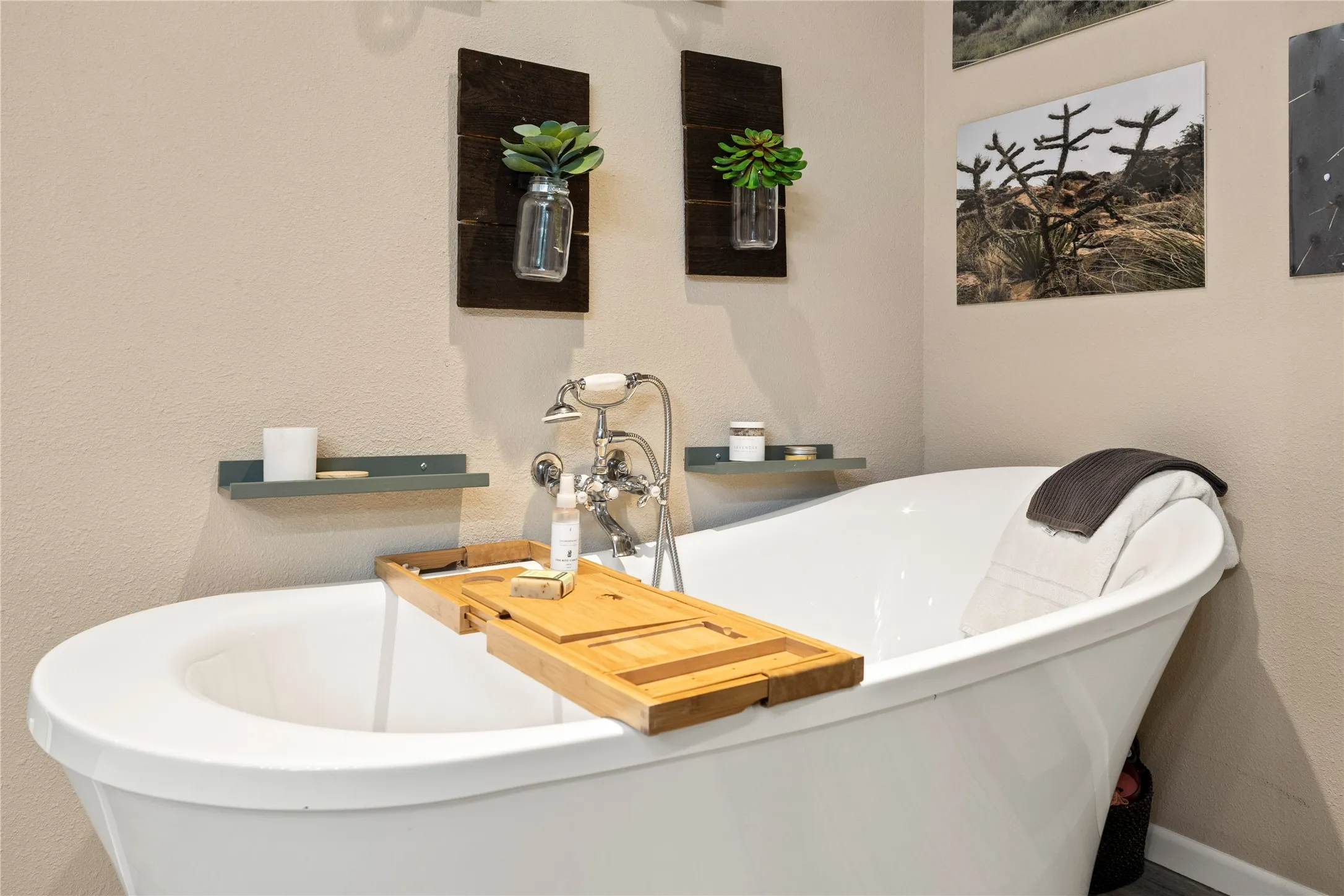 Freestanding soaking tub with polished chrome fixtures and an integrated hand shower