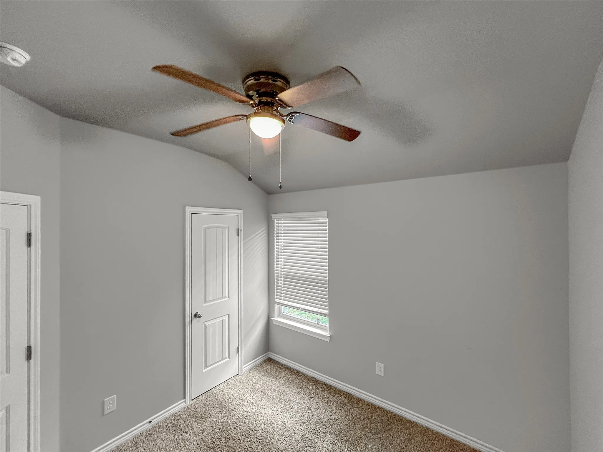Vaulted ceiling featuring a wood-finish ceiling fan with integrated lighting