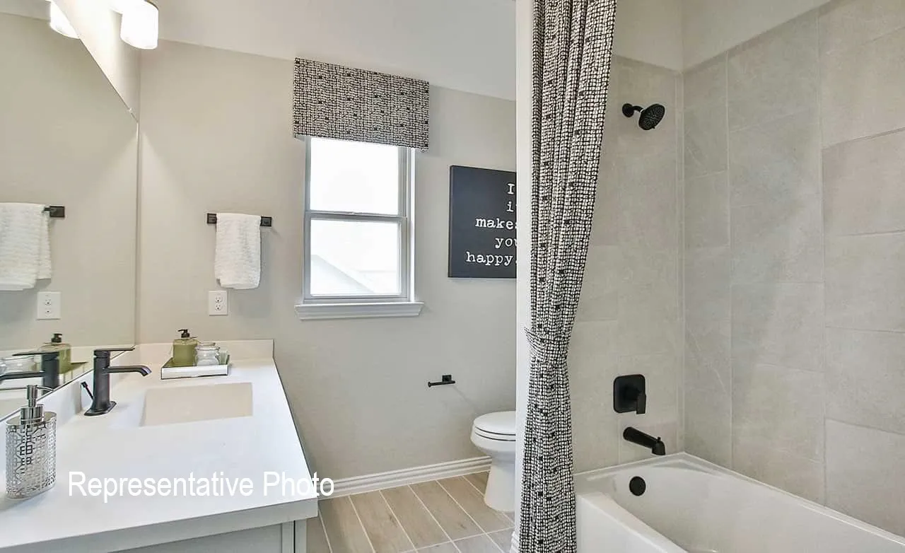 Bathroom featuring a single vanity with integrated rectangular sink, matte black faucet, and a large mirror