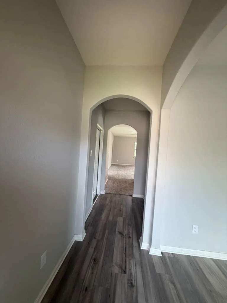 Archway entry featuring wood-finish flooring and neutral wall tones