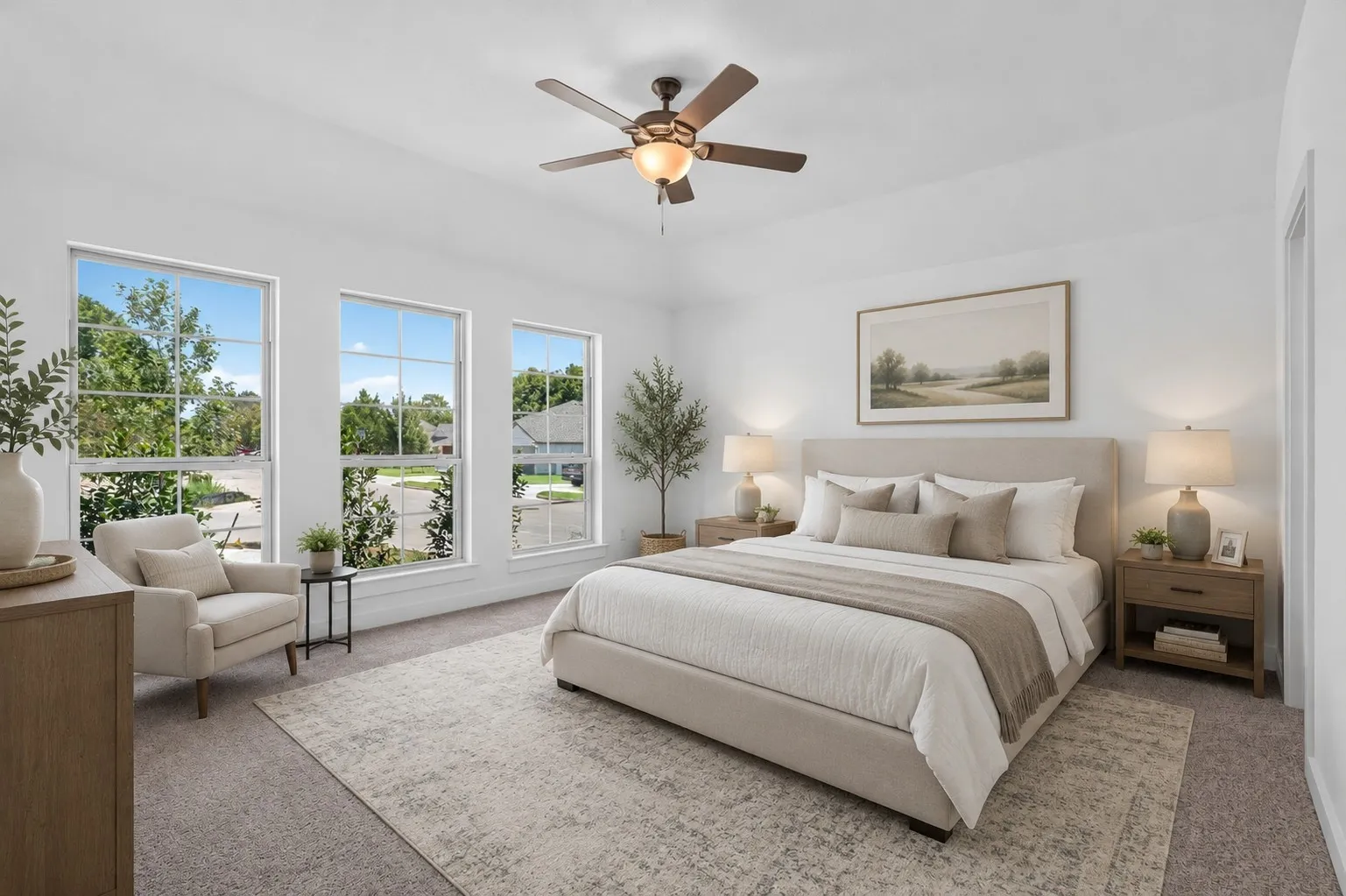 Spacious bedroom featuring three large windows, a ceiling fan with integrated lighting, and neutral carpeting