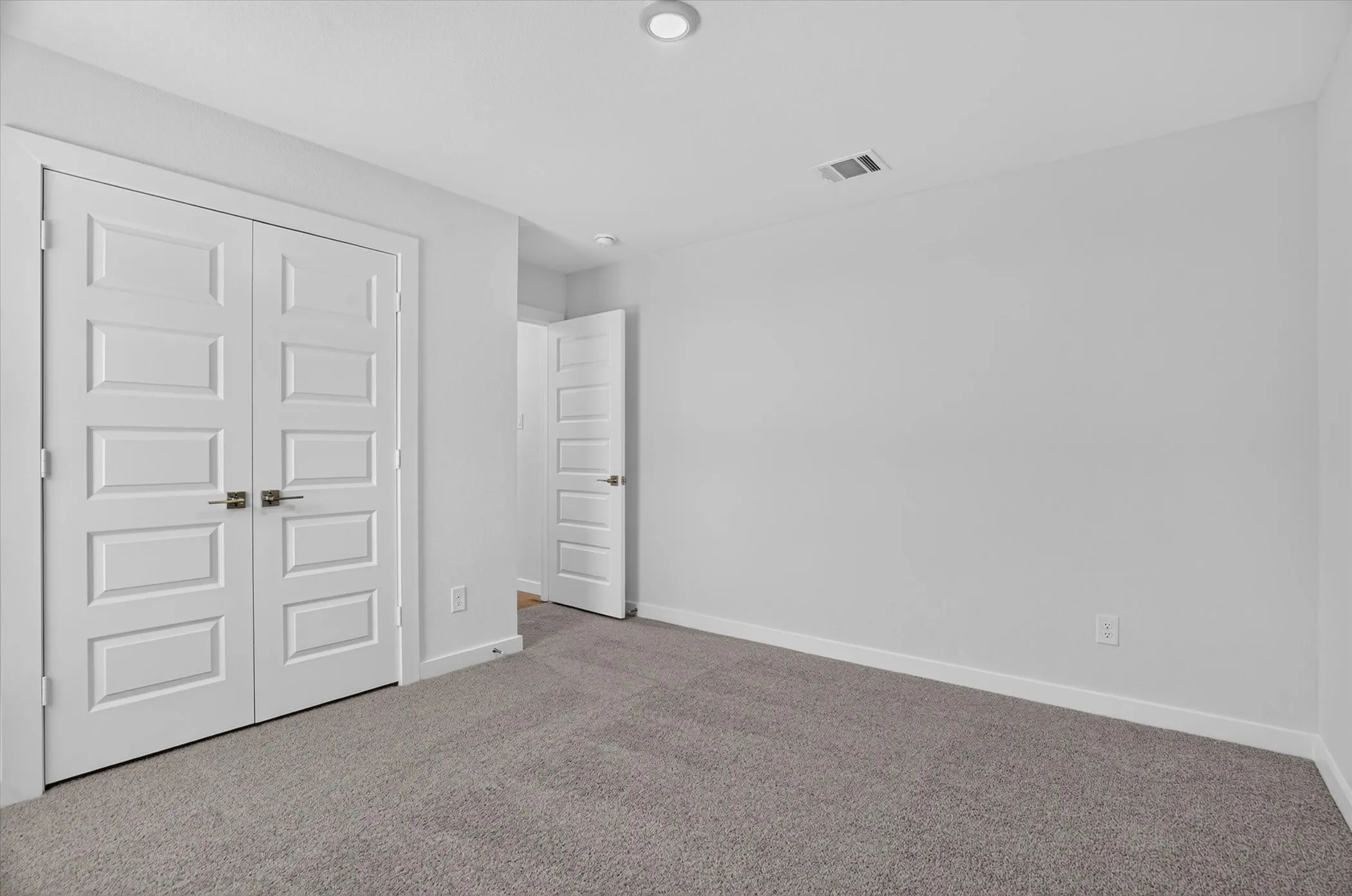 Neutral gray carpeting complements the bright white walls and trim