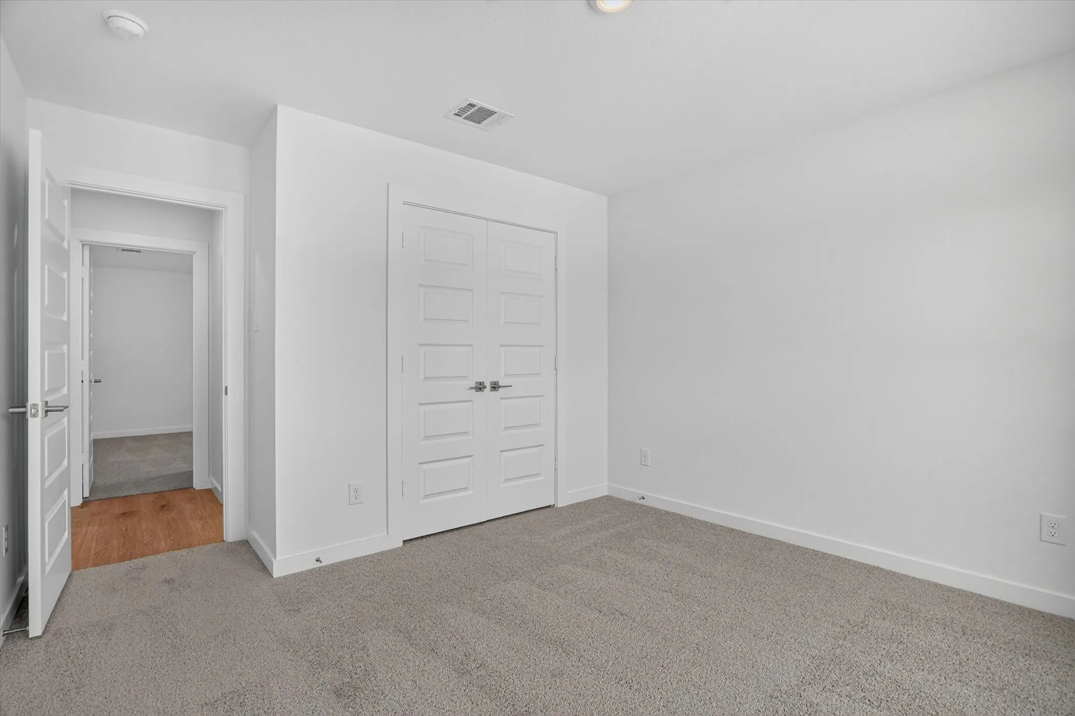 Neutral gray carpeting complements the bright white walls and trim