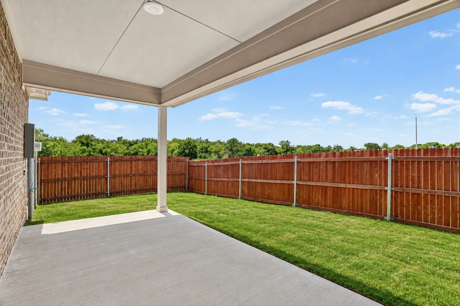 Spacious covered patio featuring a concrete slab and ceiling-mounted lighting