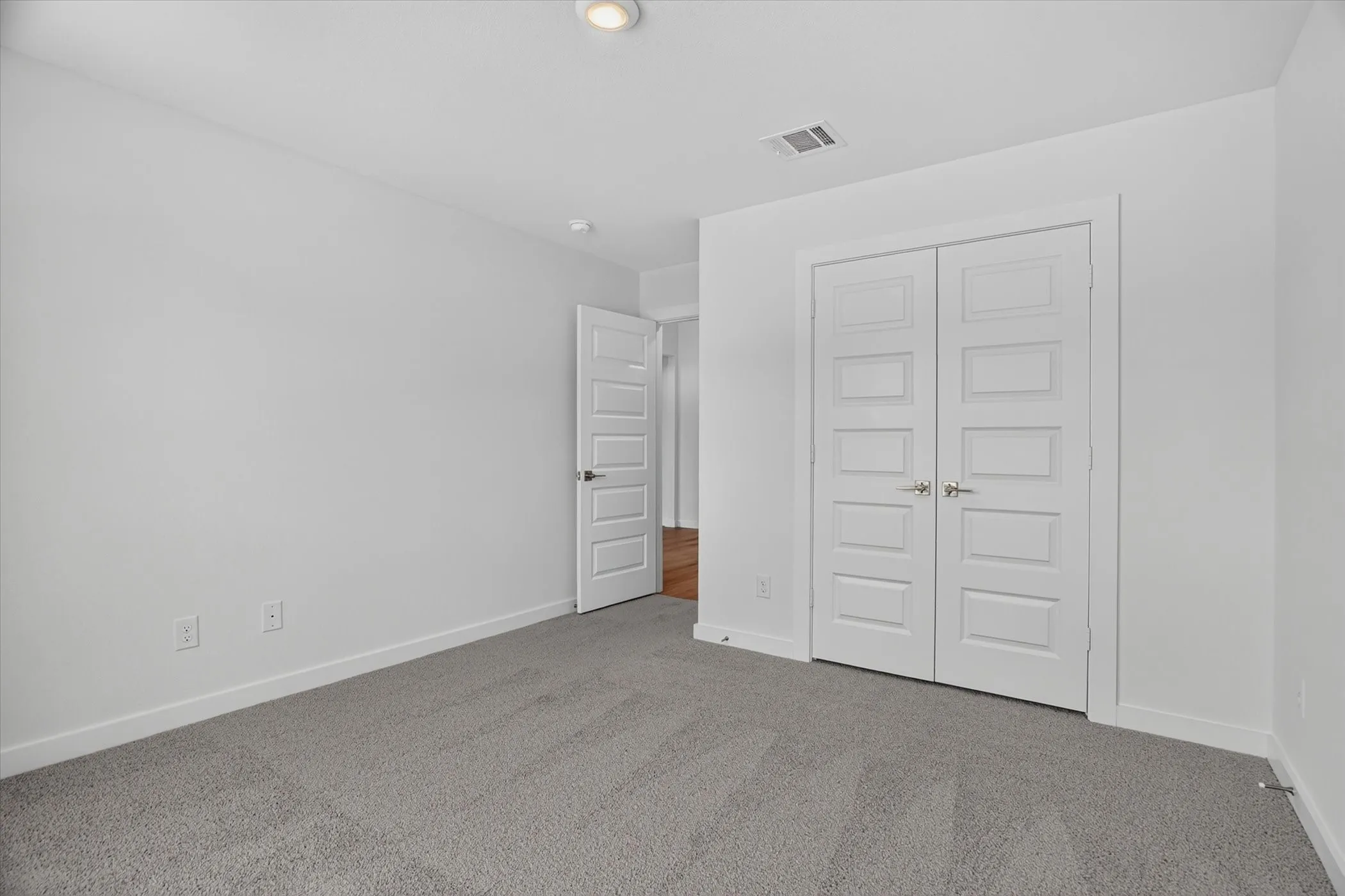 Carpeted room featuring white walls, white baseboards, and a recessed ceiling light