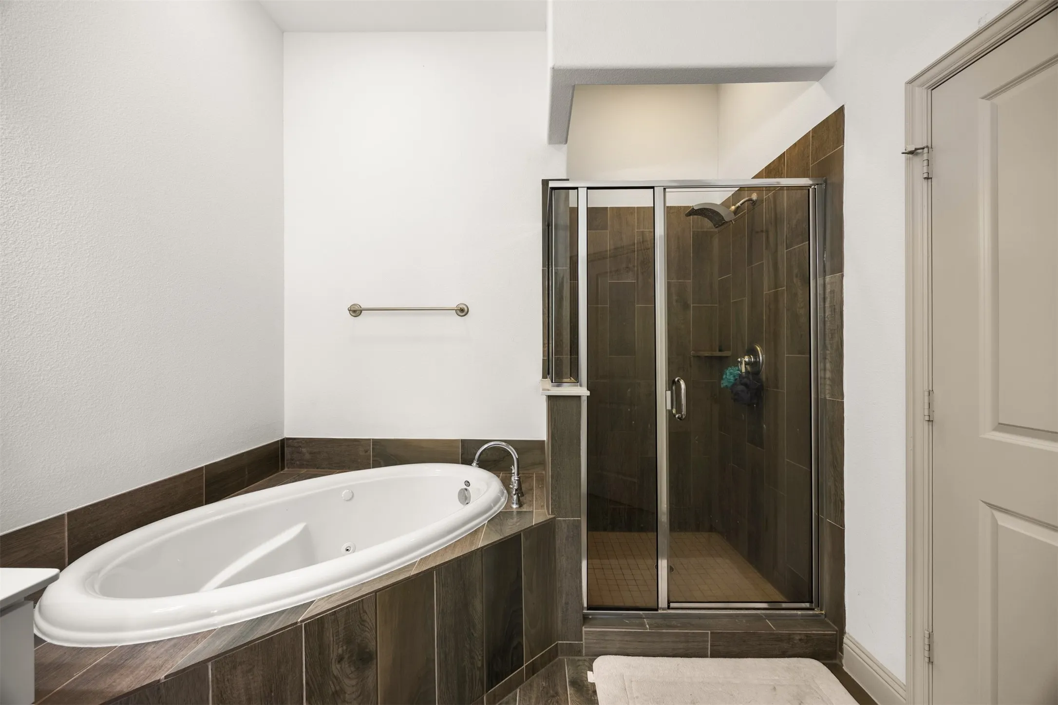 Bathroom featuring a built-in soaking tub and a glass-enclosed shower with a rain showerhead
