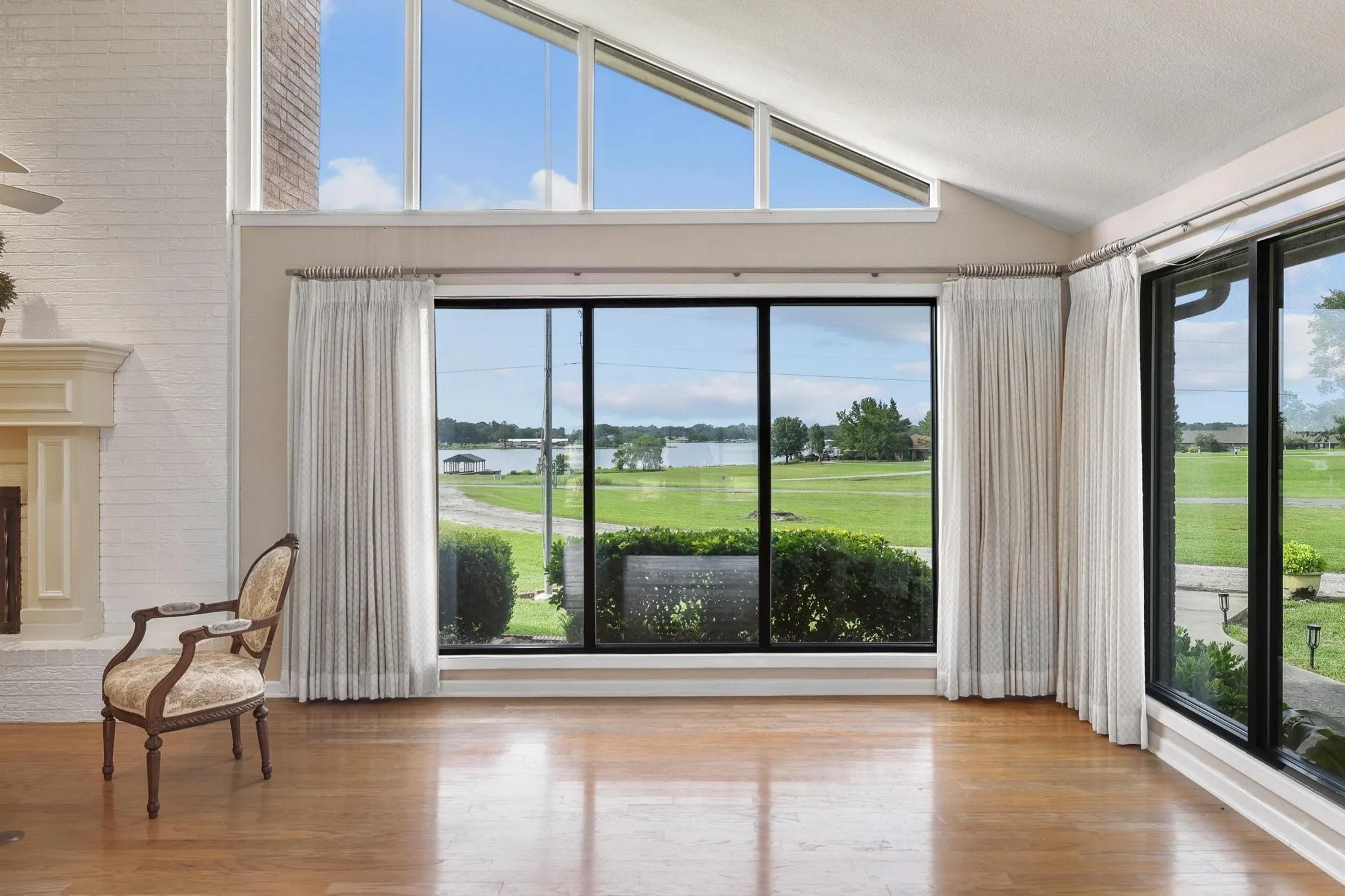 Stunning lake view from Open and airy living room.  Vaulted ceiling, fireplace floor to ceiling windows!
