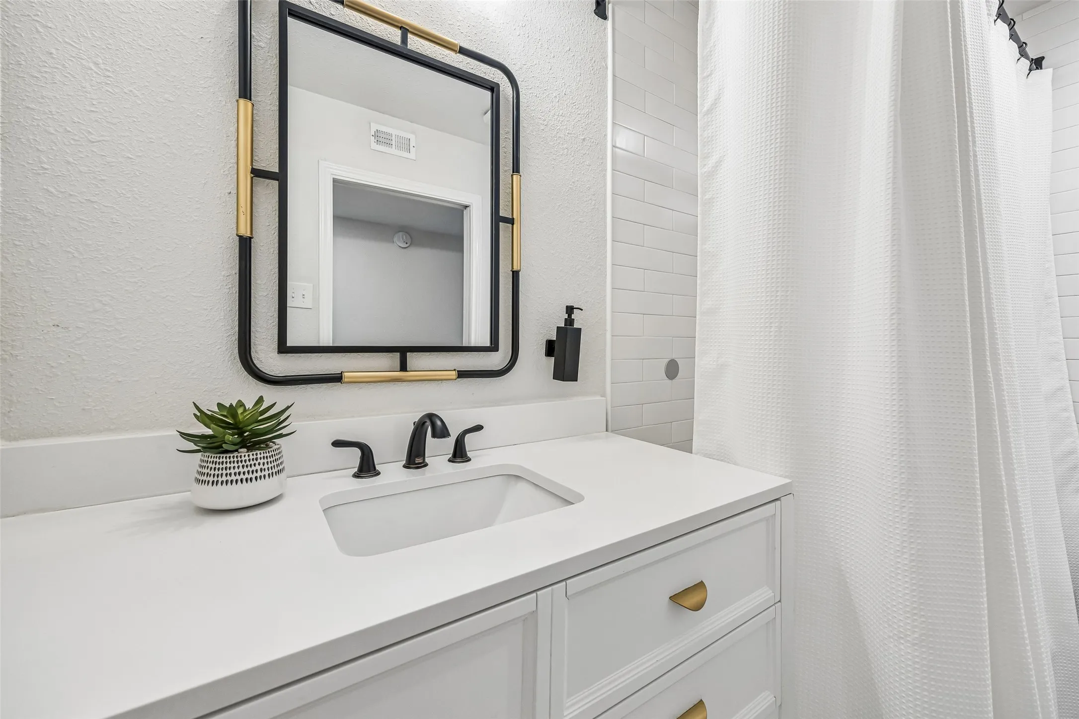 The third bath is crisp and white with ample vanity storage.