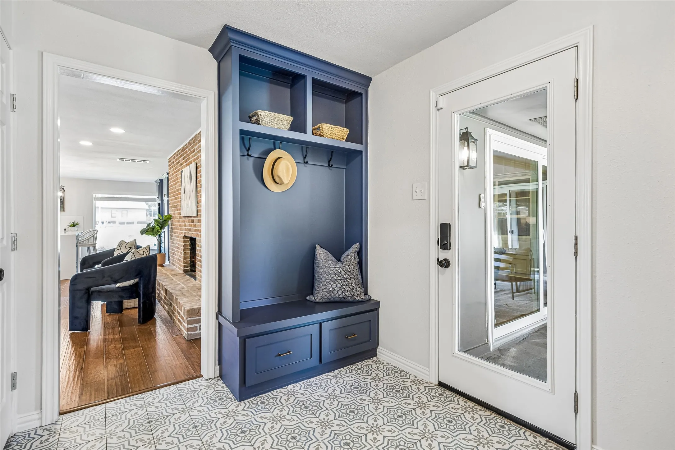 The large mudroom includes built-in cubbies, patio access and full-sized laundry station. Attractive flooring adds more charm to this functional space.