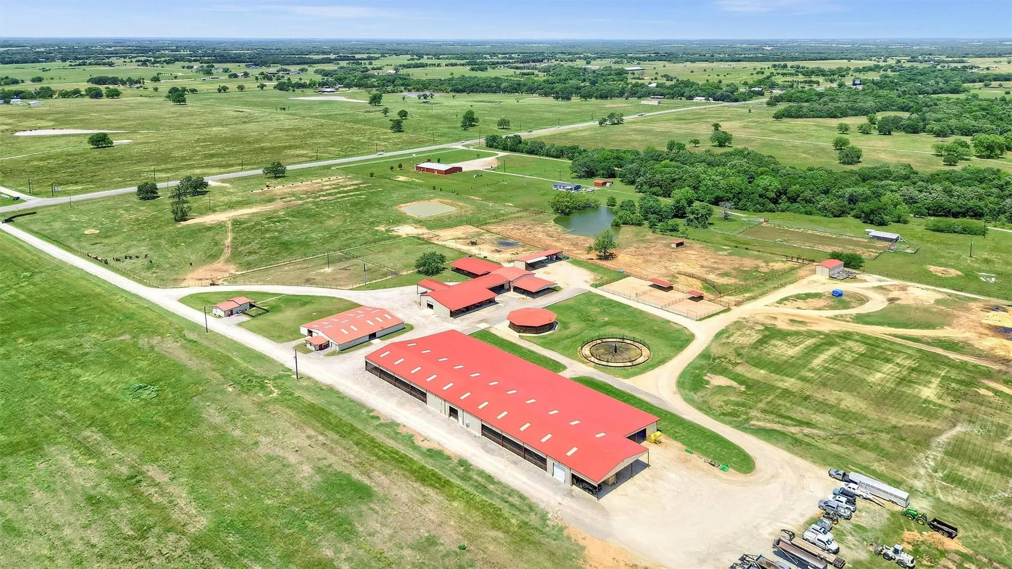 Aerial view showing adjacency of barns to the round pen and Priefert panel walker. 72-stall barn in foreground.