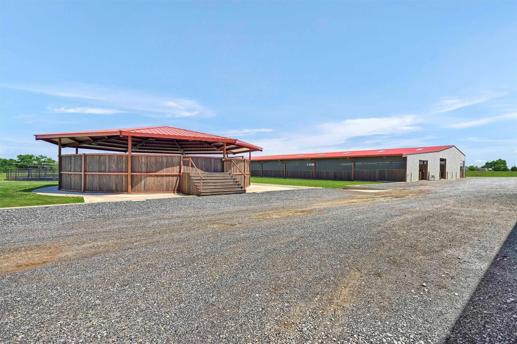 Entrance to the round pen with 72-stall barn in the background.