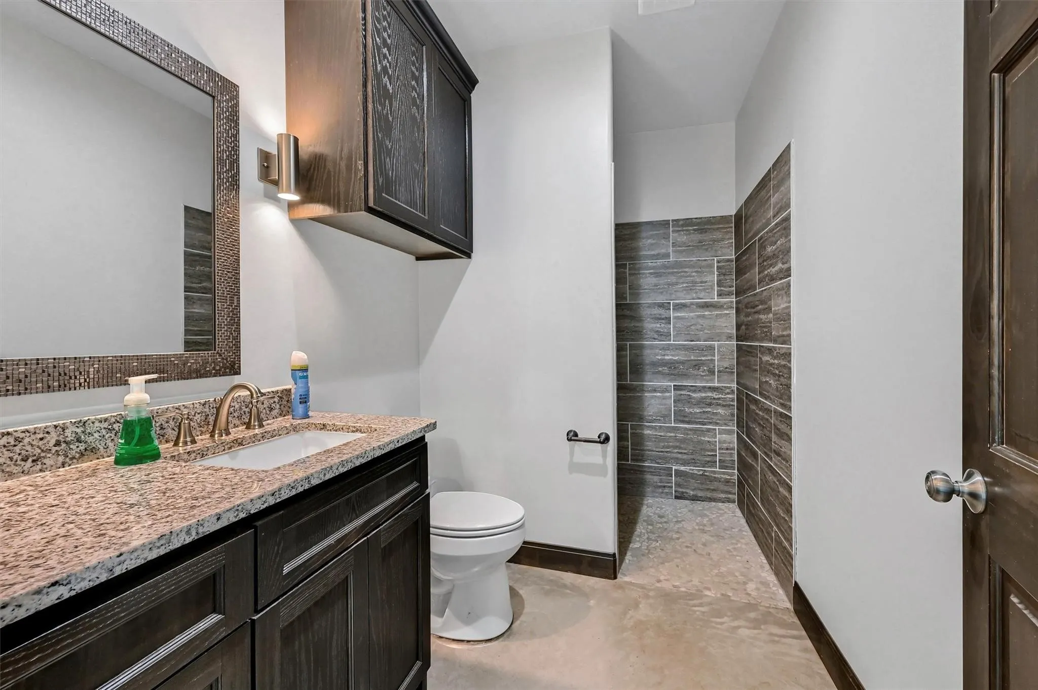 Full bathroom with custom, oversized shower off visitors lounge.