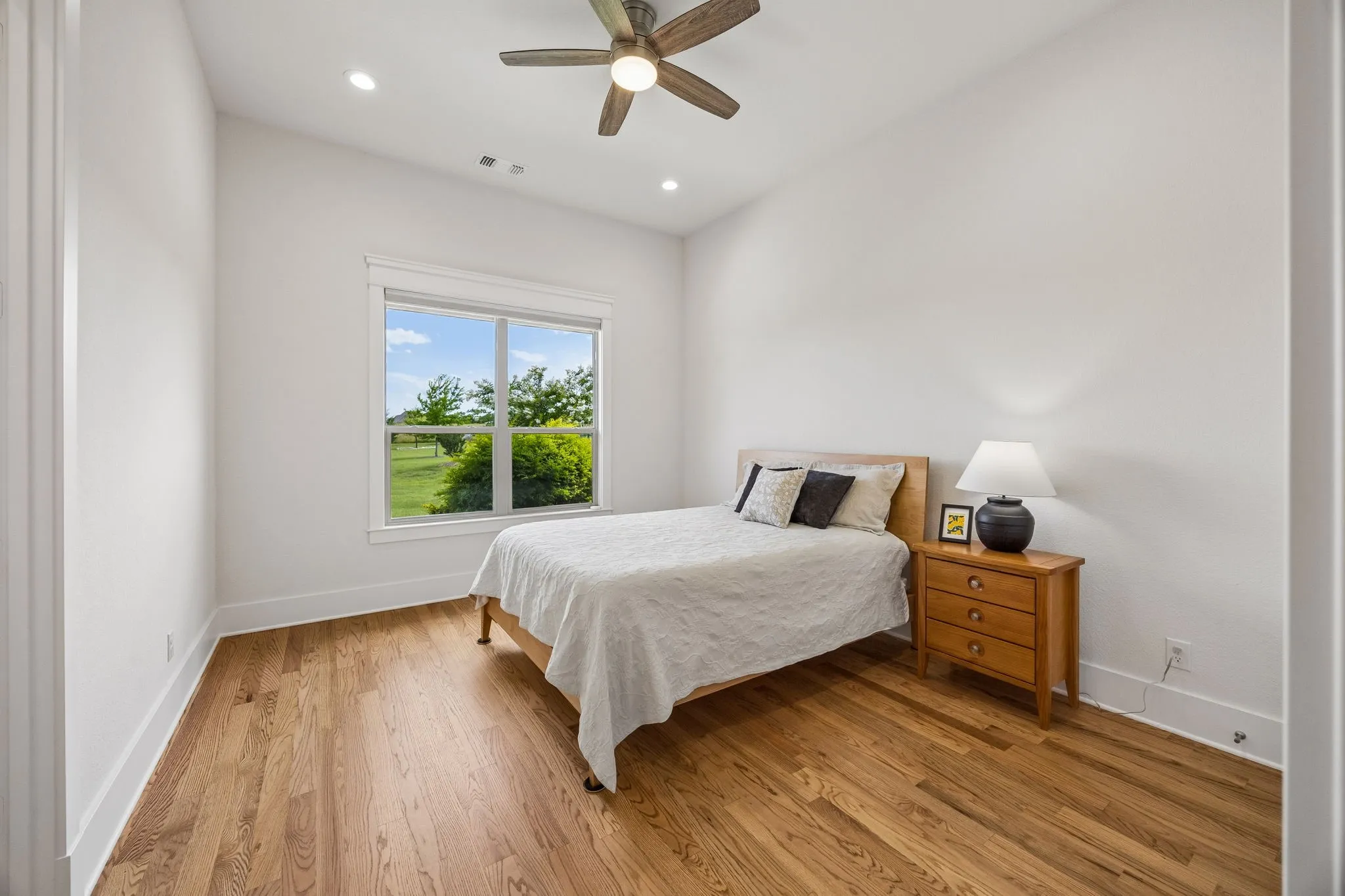 Large guest suite with walk-in closet and private bath featuring double sinks, oversized walk-in shower, and exterior access to outdoor living.