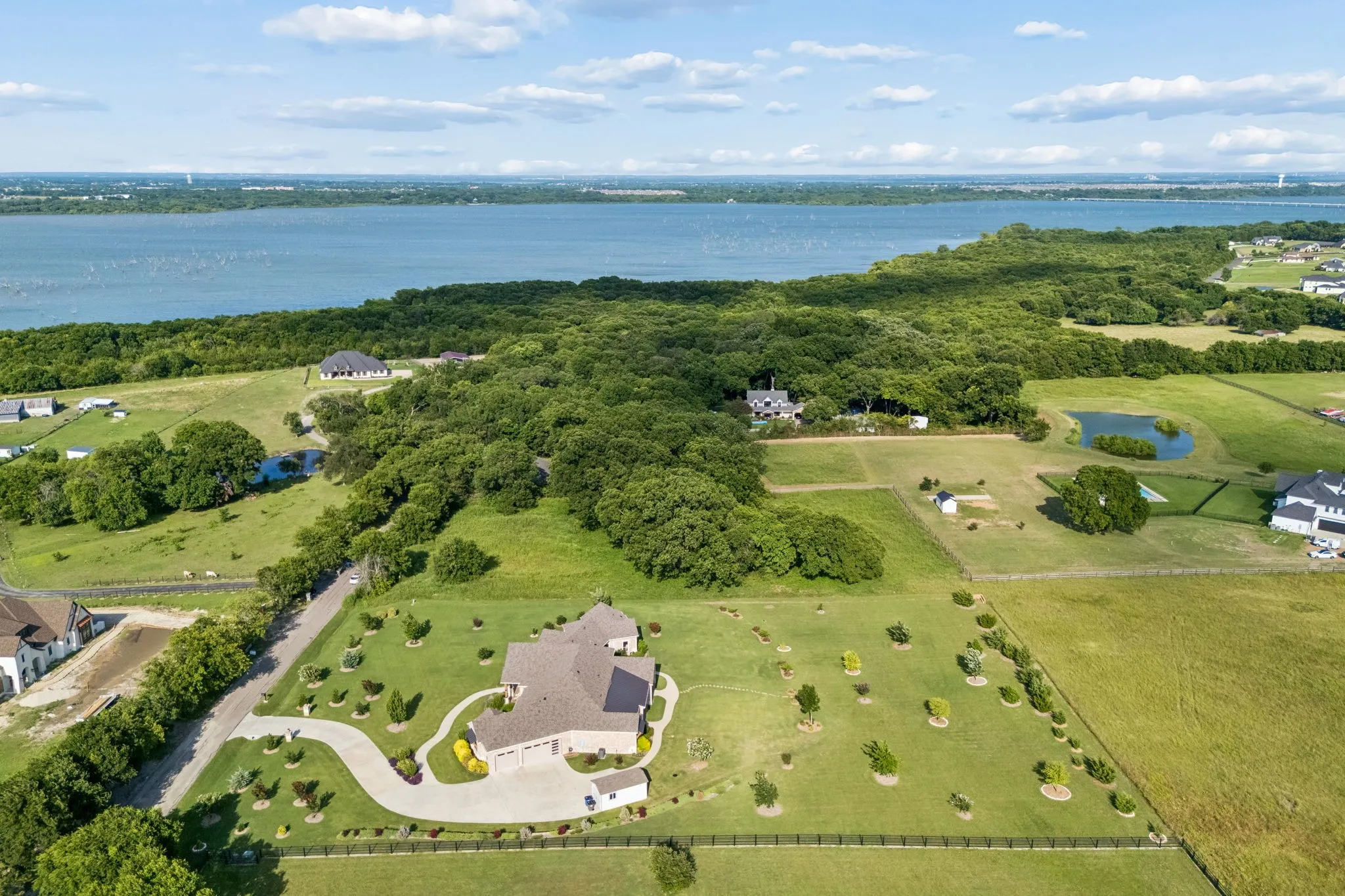 Expansive property featuring a single-story residence, a winding driveway, and extensive green space