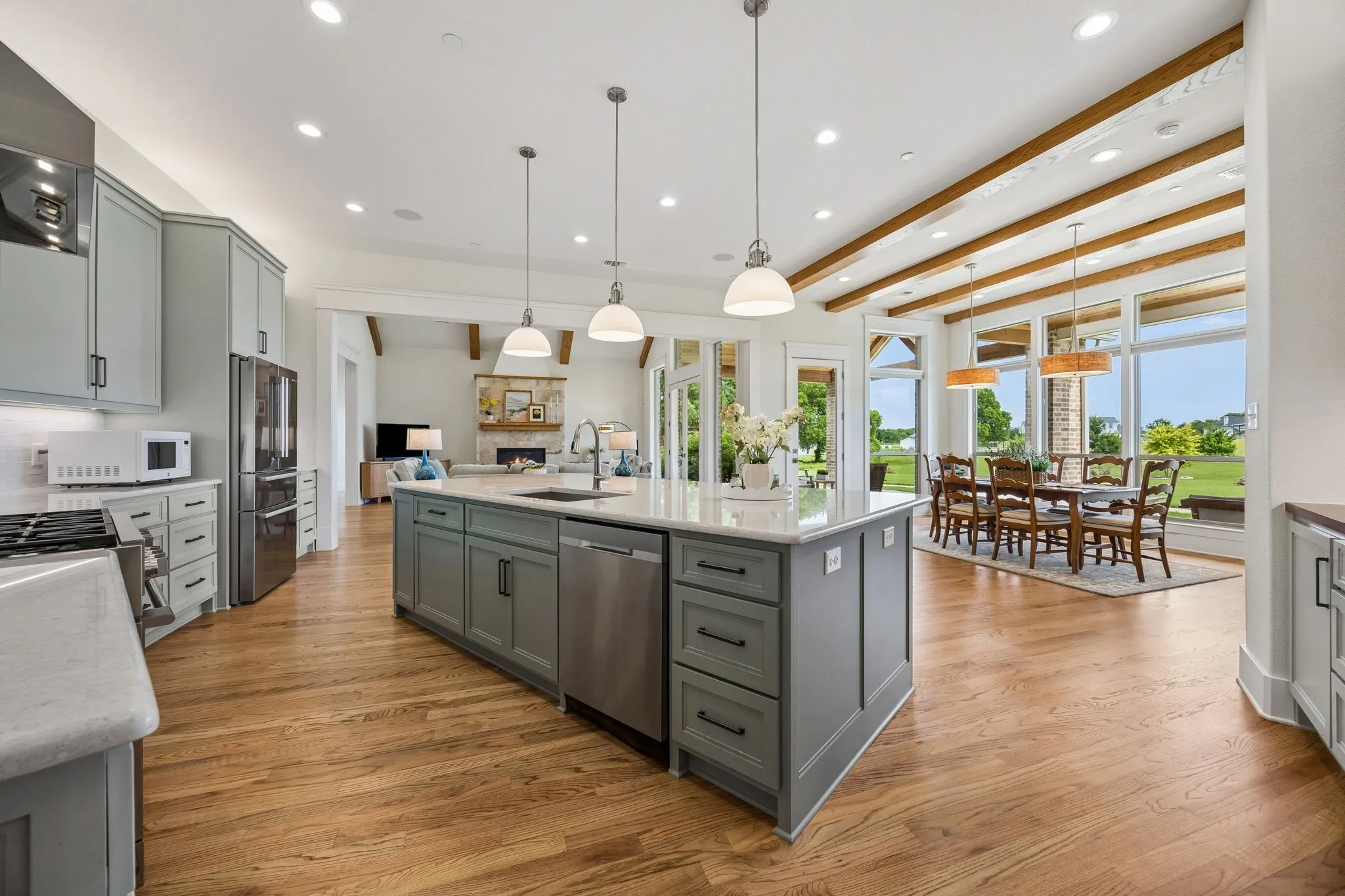 The spacious, sunlit dining room adjoins the gourmet kitchen is fully equipped with a 6-burner commercial-grade range and hood, custom shaker cabinetry, white subway tile backsplash, built-in hutch, walk-in pantry, and large center island with breakfast bar seating.