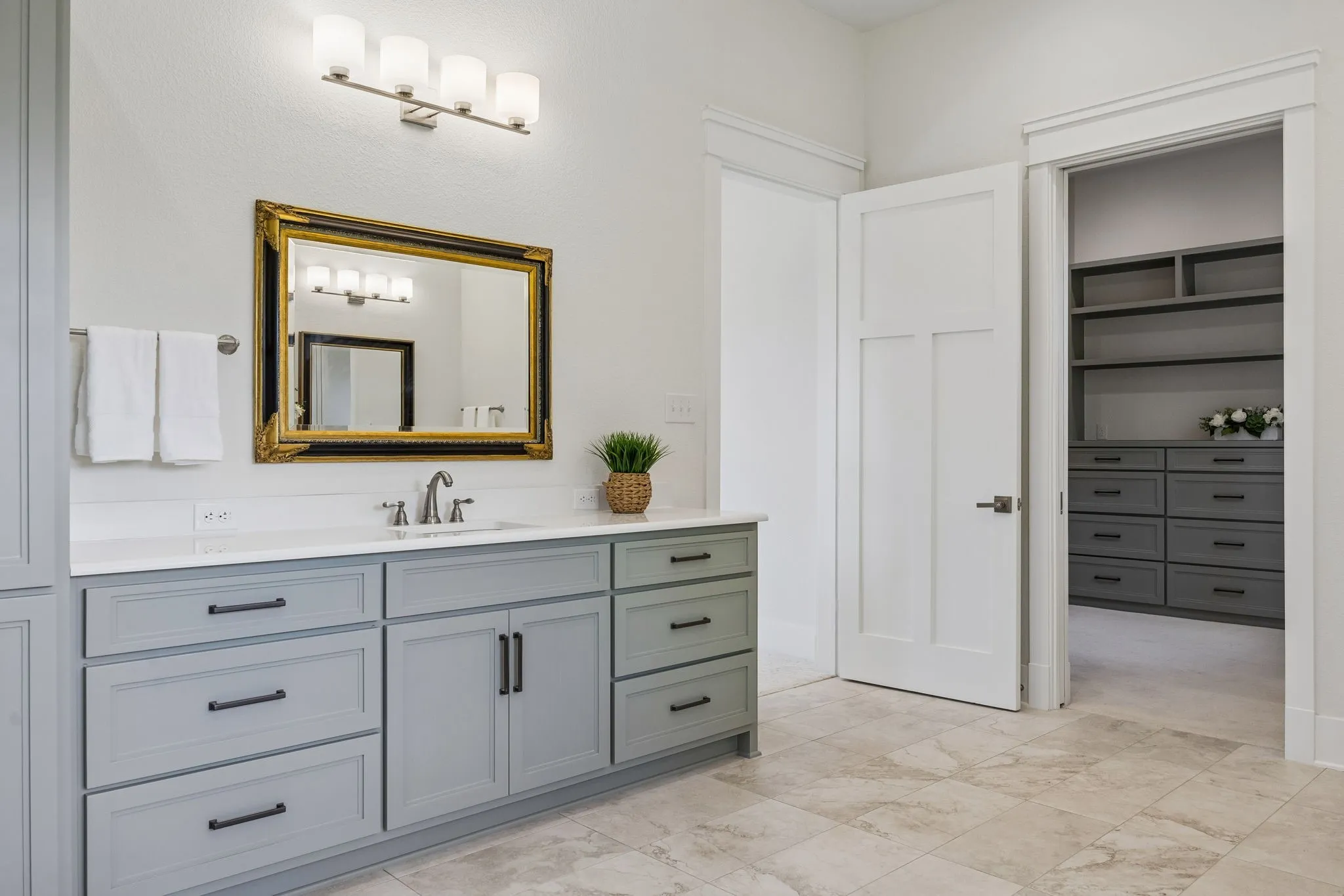 The luxurious primary spa bath features large picture windows, heated tile floors, freestanding soaking tub, large roll-in shower, separate vanities with shaker cabinetry and quartz countertops.