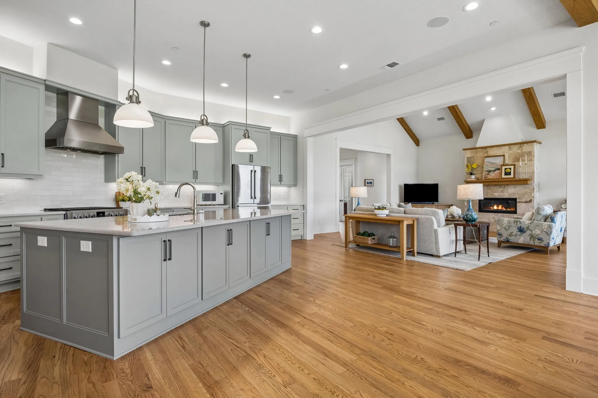 The gourmet kitchen is fully equipped with a 6-burner commercial-grade range and hood, custom shaker cabinetry, white subway tile backsplash, built-in hutch, walk-in pantry, and large center island with breakfast bar seating.