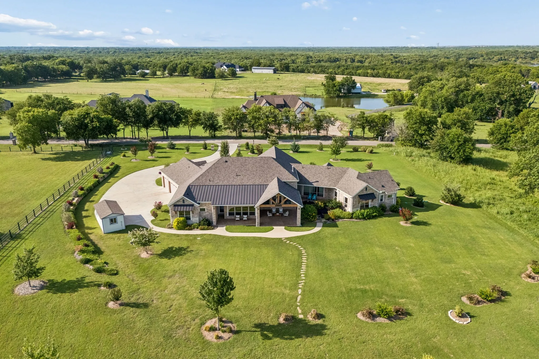 Sprawling estate featuring a stone and siding exterior with multiple gables and a covered patio
