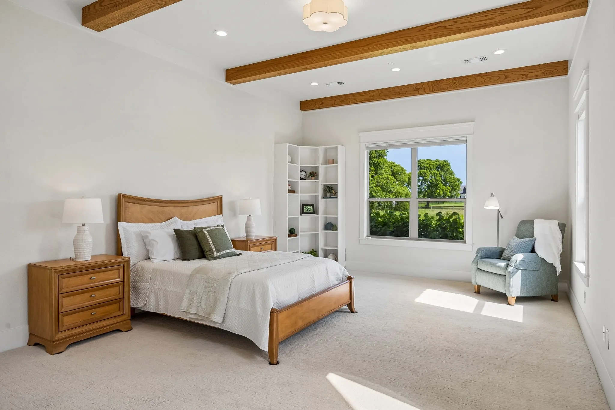 A gallery-style hallway leads to the primary suite, tucked away with exposed wood beams, tranquil views, luxurious spa bath, and large custom closet.